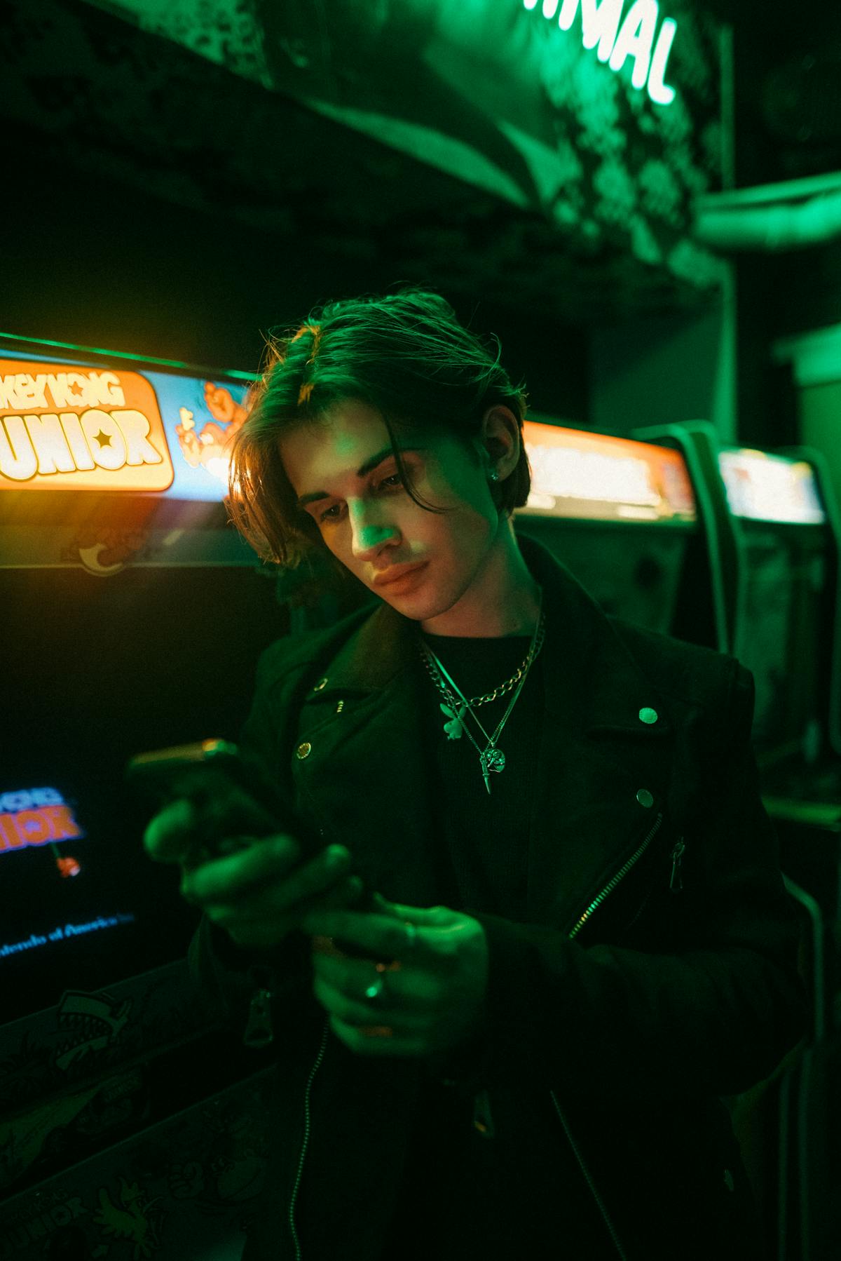 Young man in a neon-lit arcade with a retro glow