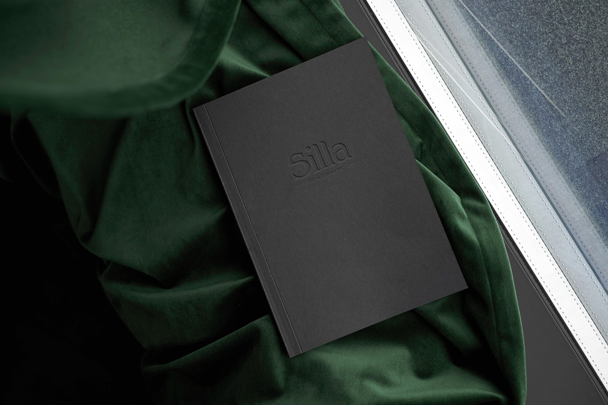 Silla Hotels And Restaurants Menu Closed Placed On A Green Blanket