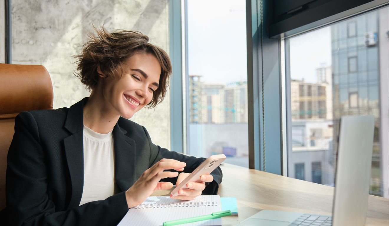 Imagem mostra uma mulher sorrindo com o celular aberto com open finance