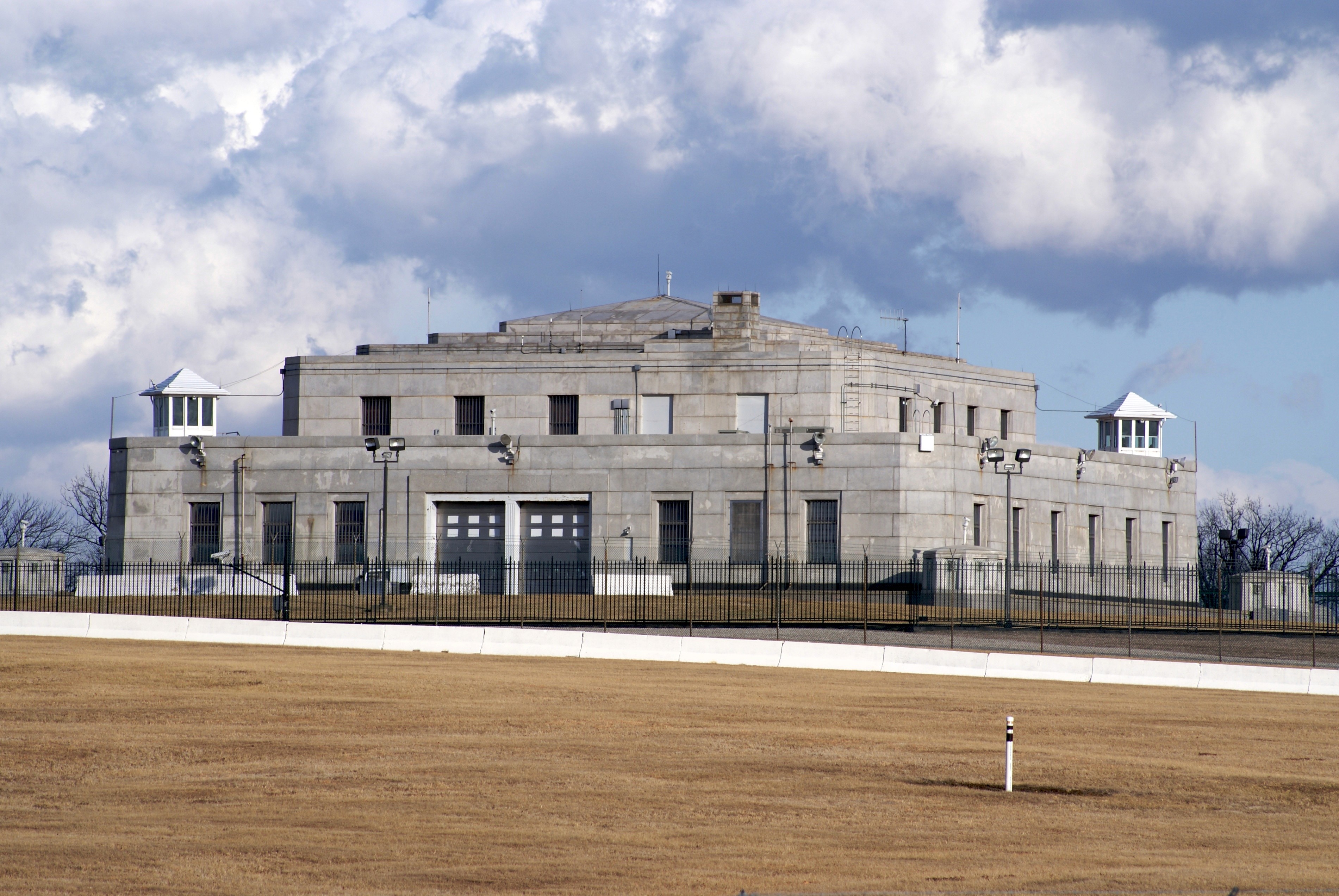 Fort Knox gold depository exterior, heavily fortified granite building surrounded by iron security fencing.