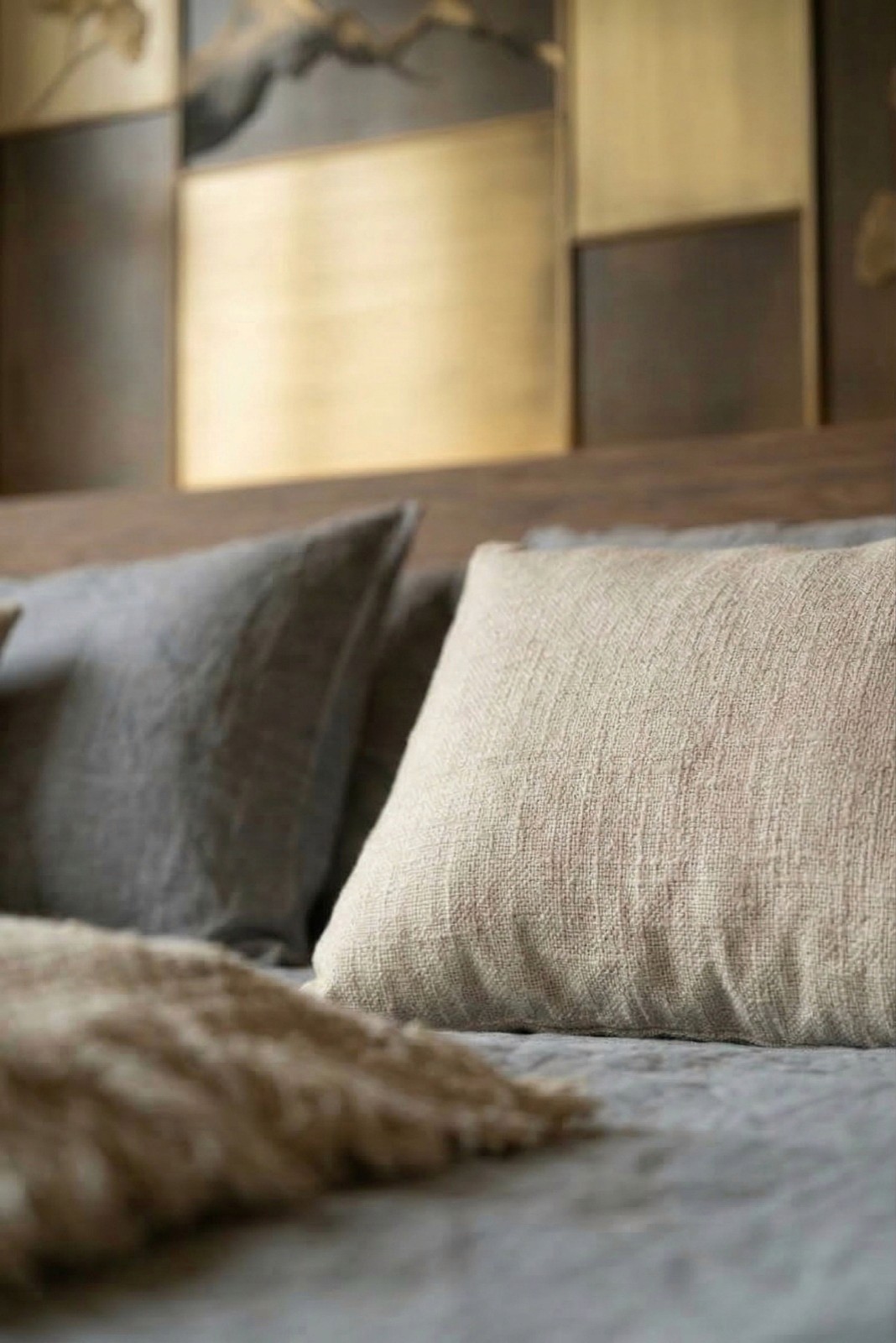 Vintage-modern living room with tufted sofas, false ceiling, and layered warm lighting.