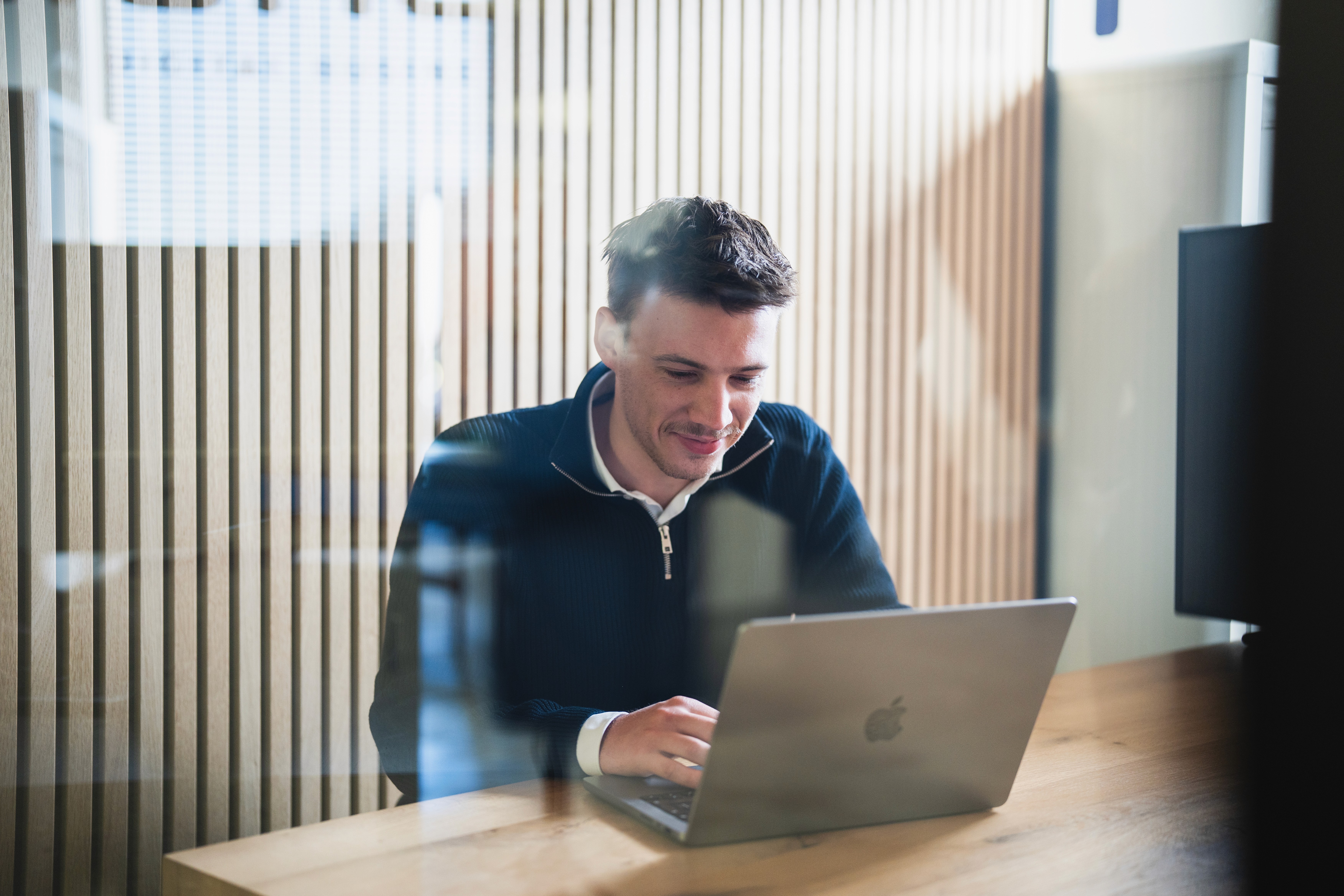 Saskia van Pionect kijkt van haar scherm op en glimlacht terwijl ze op haar laptop typt