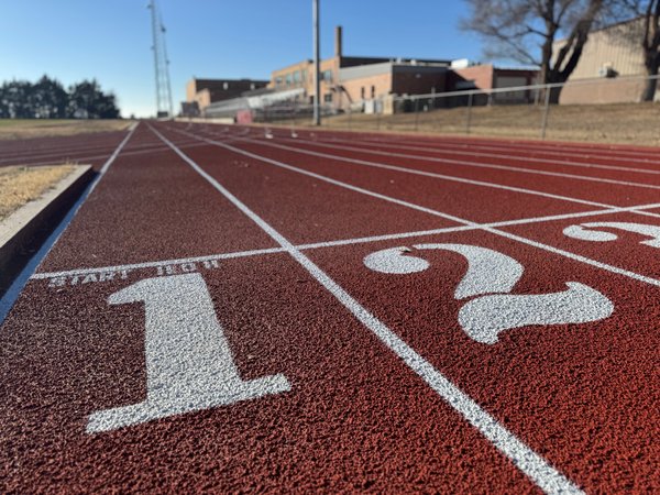 White lane numbers painted at the start line of a red track