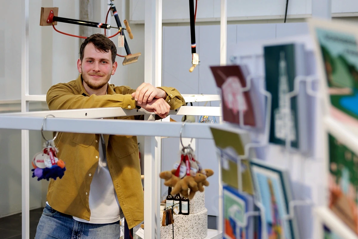 Medewerker in een VVV-winkel met ansichtkaarten en souvenirs