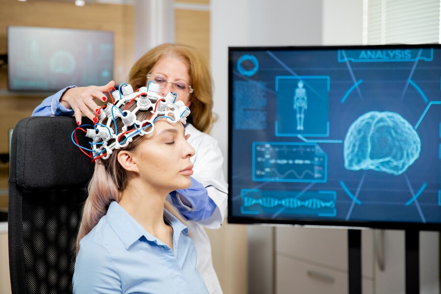 A doctor arranging a scanning device on her patients head.