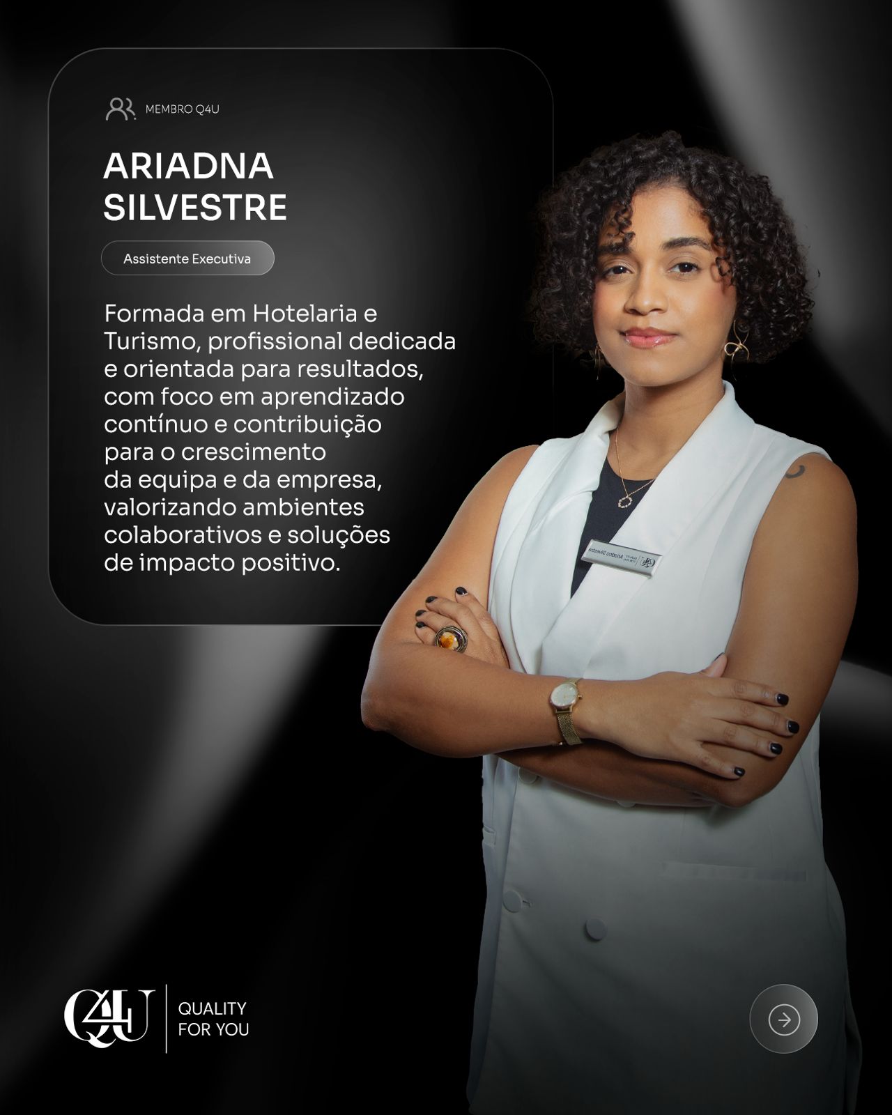 A man with glasses and a beard stands indoors, wearing a white shirt and suspenders. He looks calm by a window with floral curtains and a floral painting.