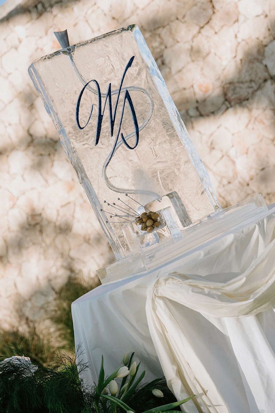 Monogrammed Clear Ice luge on a short table outside