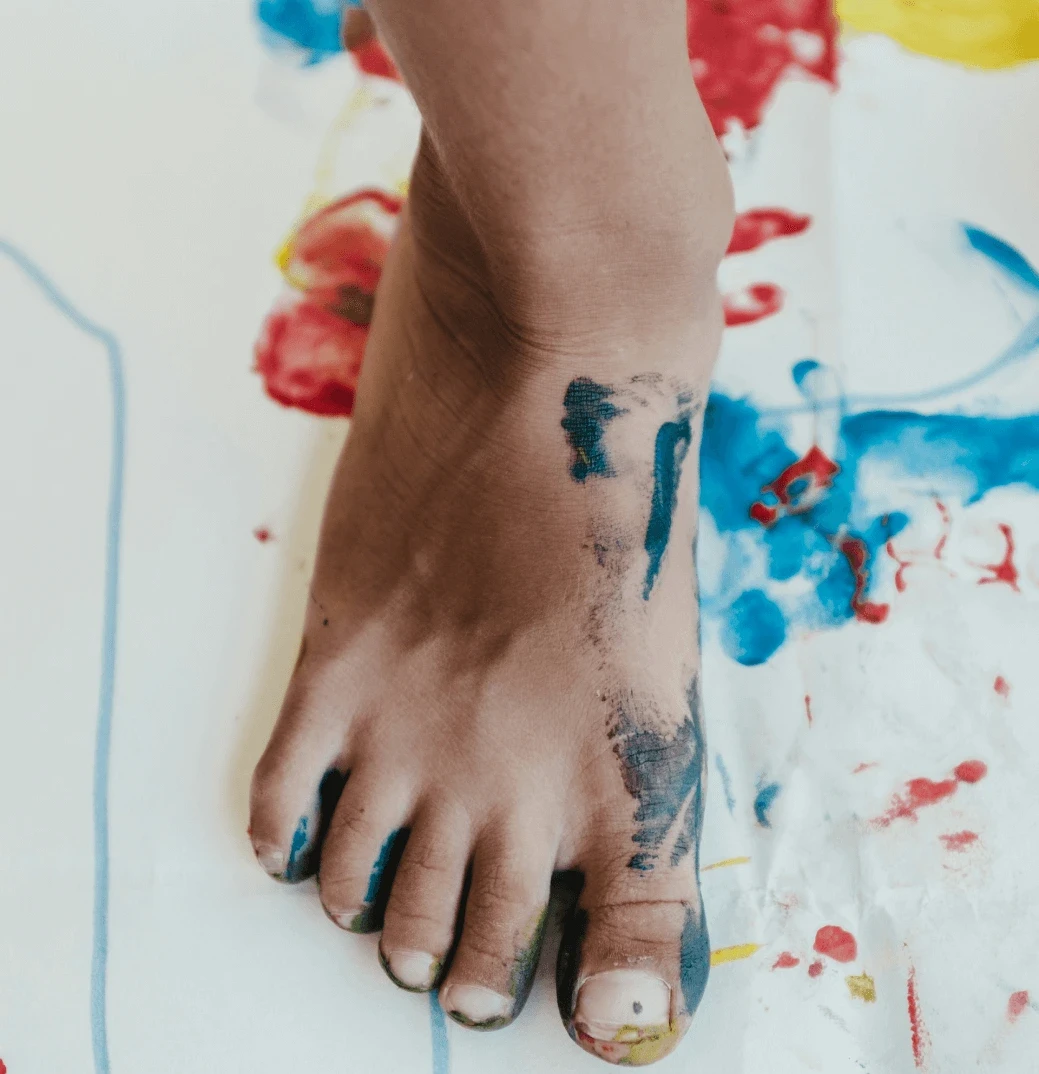 a kid's foot with paint around