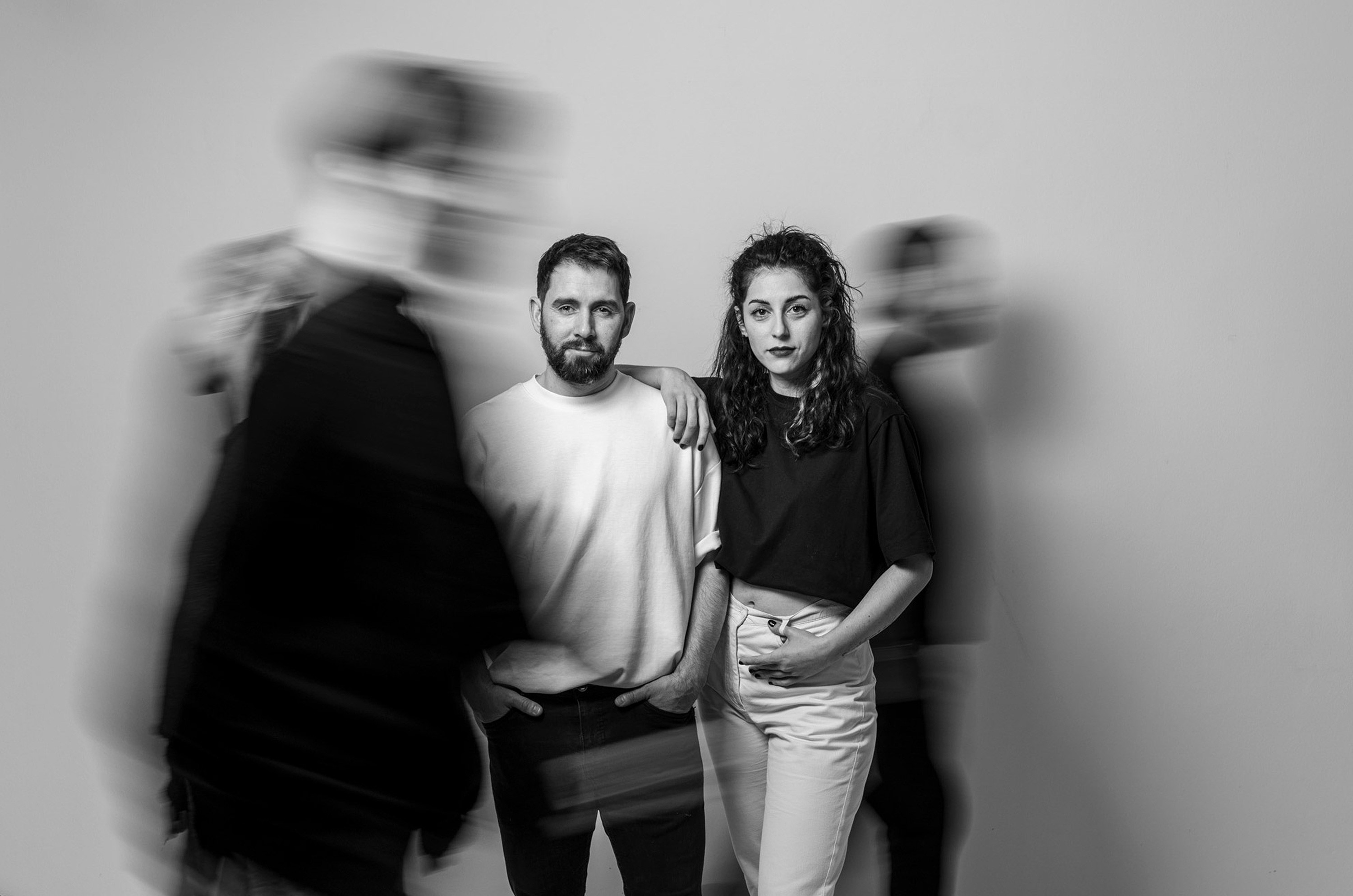 Black and white brand photoshoot featuring two people in a minimalist studio setting.