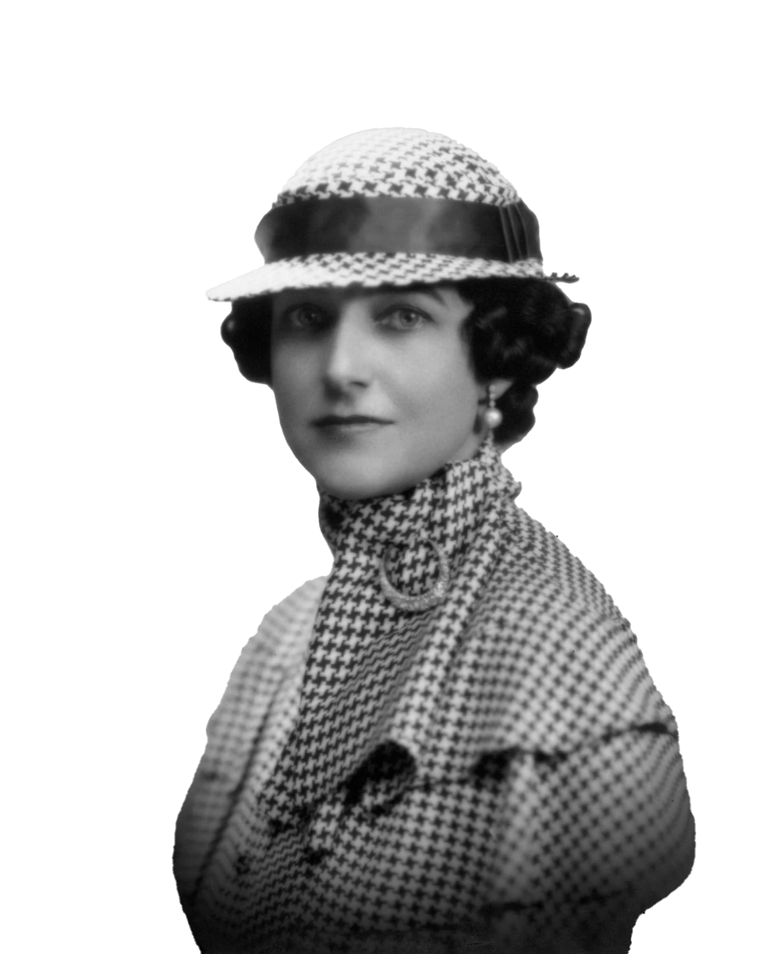 A vintage black-and-white portrait of a woman wearing a stylish houndstooth-patterned outfit, including a matching hat with a glossy band and a high-necked coat. Her hair is styled in classic soft waves, and she accessorizes with pearl earrings, evoking 1930s or 1940s fashion elegance. The image exudes a timeless, sophisticated look, highlighting early 20th-century women's fashion trends.