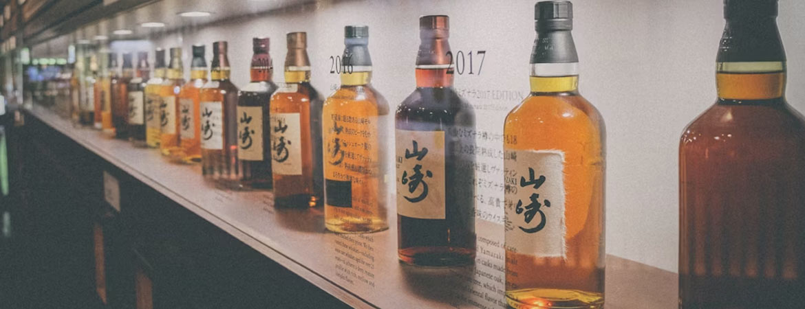 japanese whisky collection of bottles in cabinet