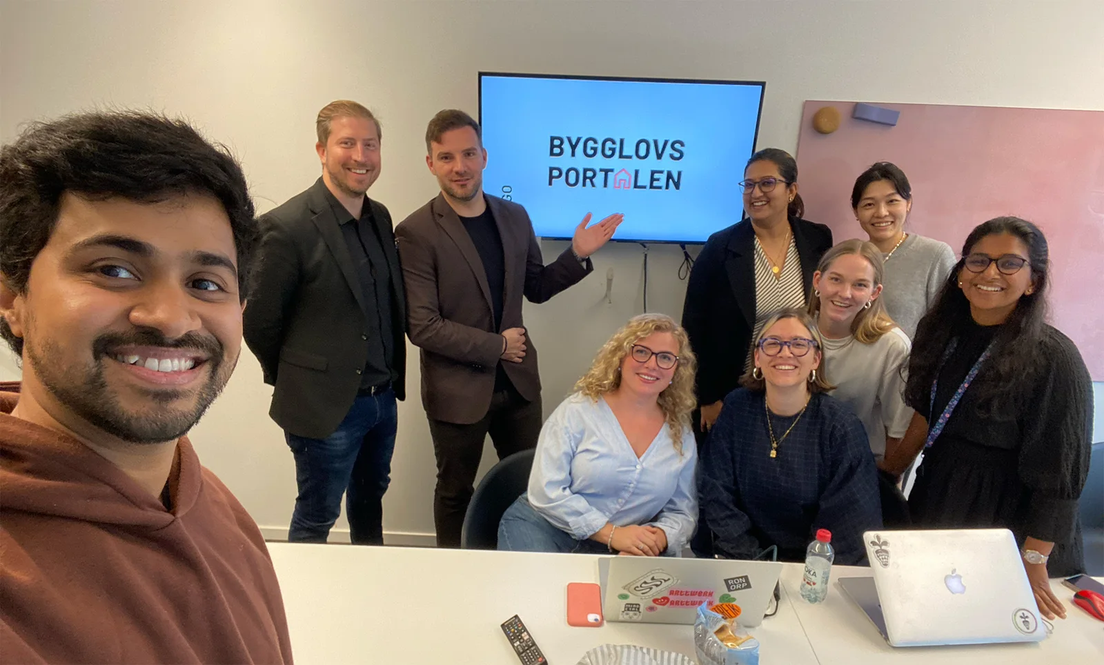 Our team with the Bygglovsportalen founders in front of a screen showing the new logo