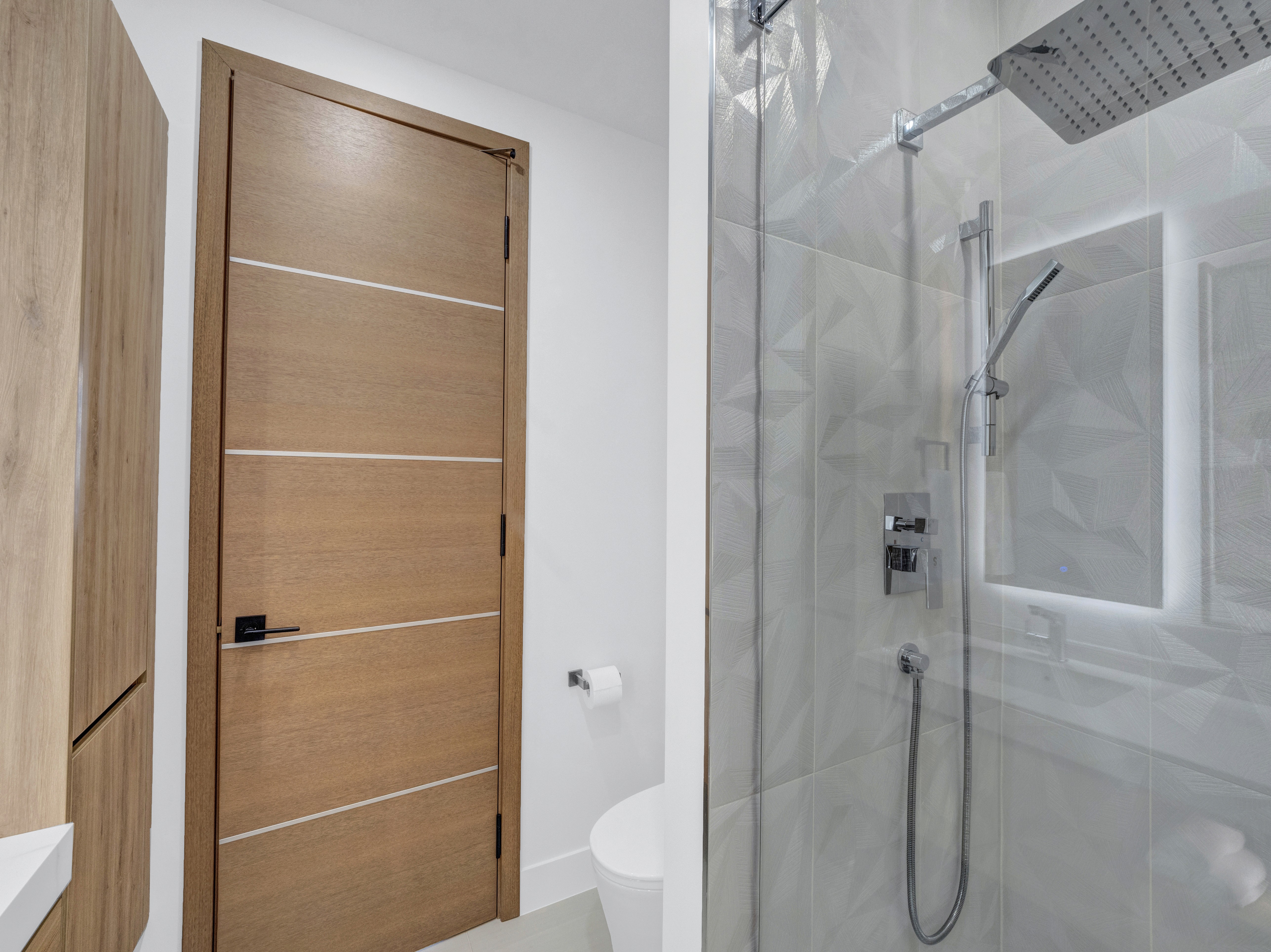 Interior view of a walk-in shower showing the high-end hardware and seamless glass partition