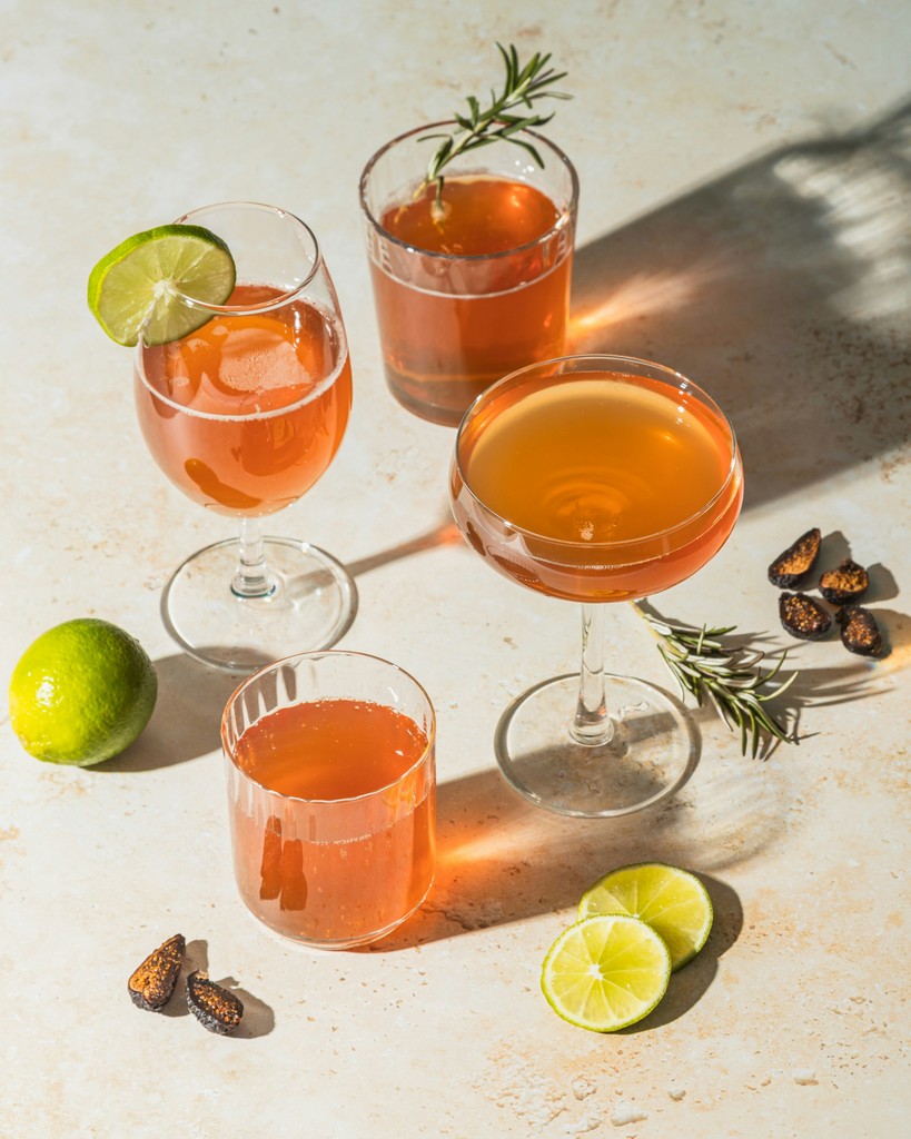 three clear drinking glasses with orange liquid