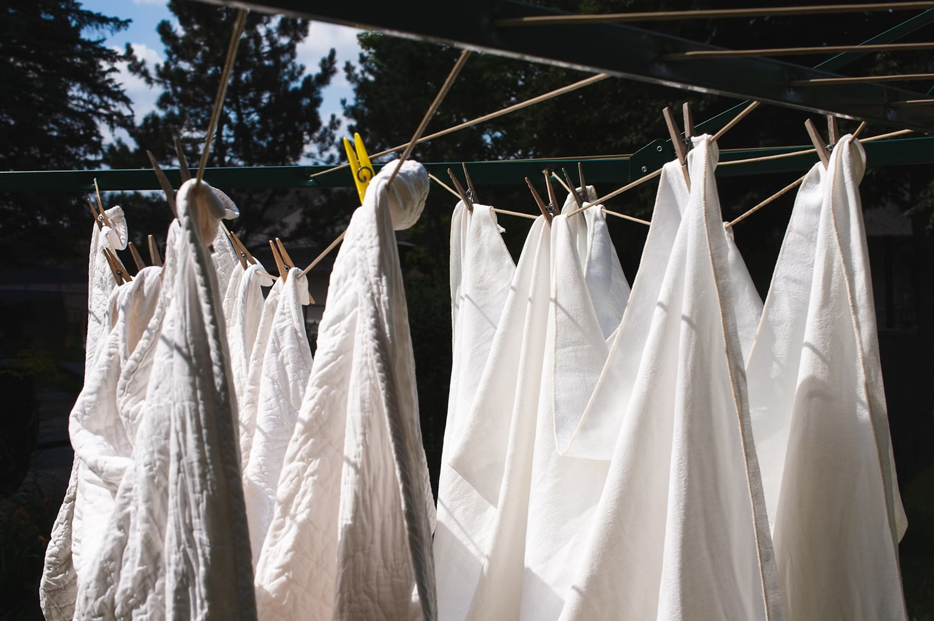 White laundry hanging on an outdoor clothesline in the garden.