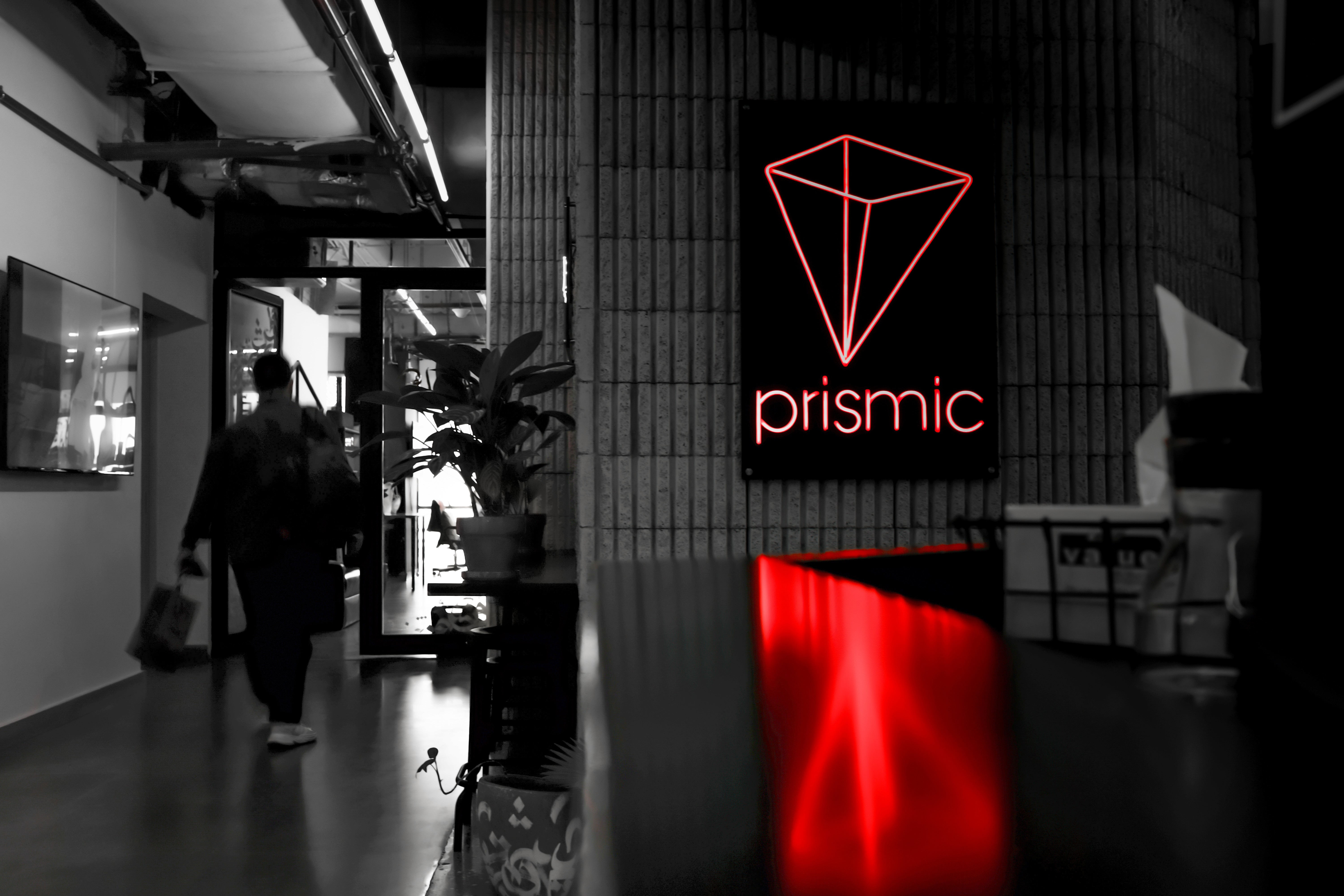 Collaborative work session overhead view of six people collaborating at a rustic wooden table with coffee, papers, and a laptop