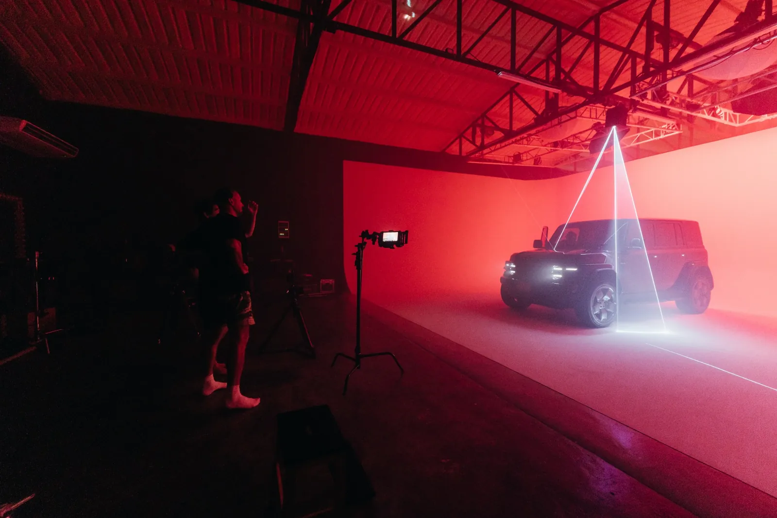 Crew at the monitor while red RGB light and a laser beam shape the Chery V23 in Studio 150