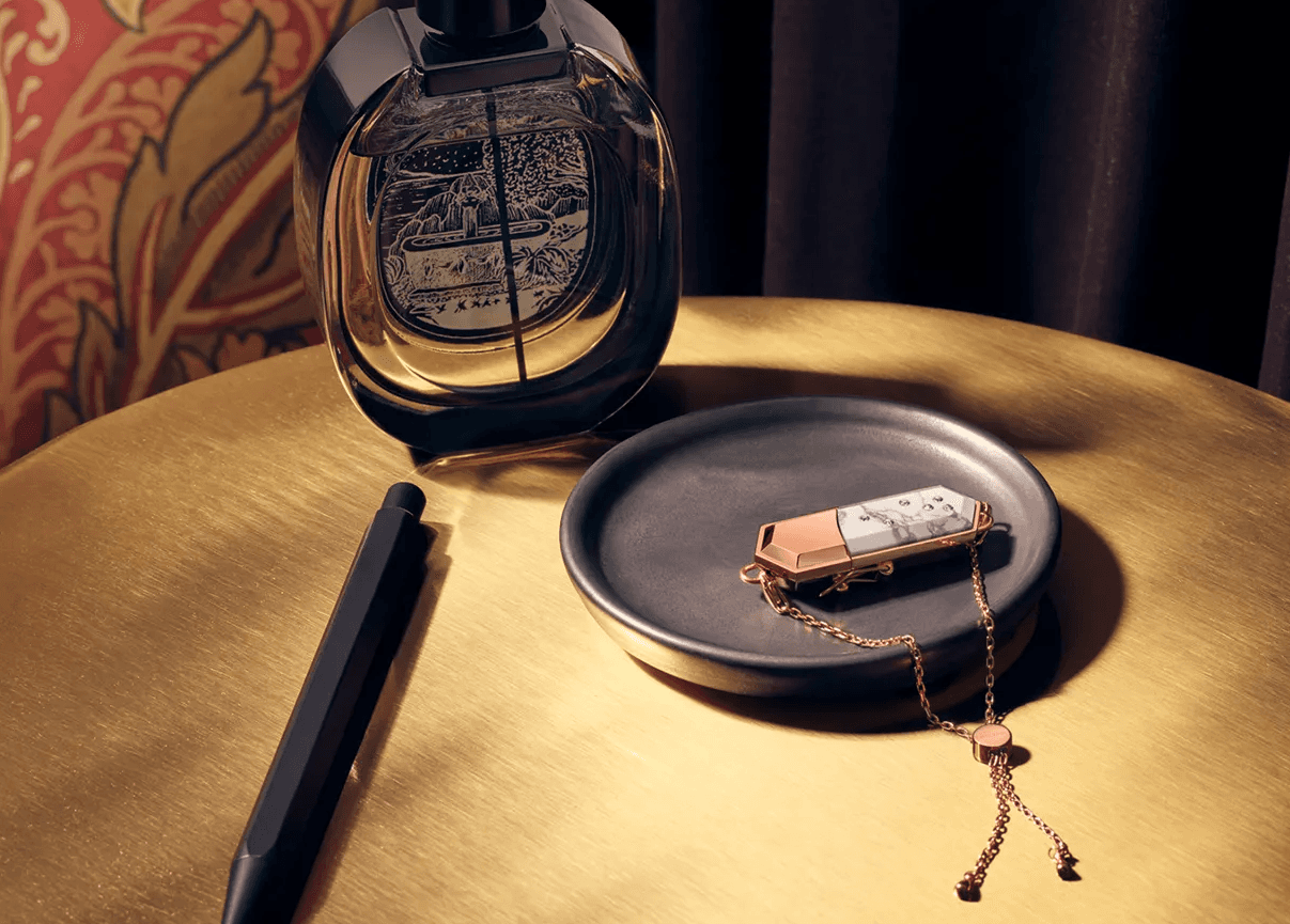 Talsam smart jewelry charm and chain displayed on a dark tray beside decorative objects