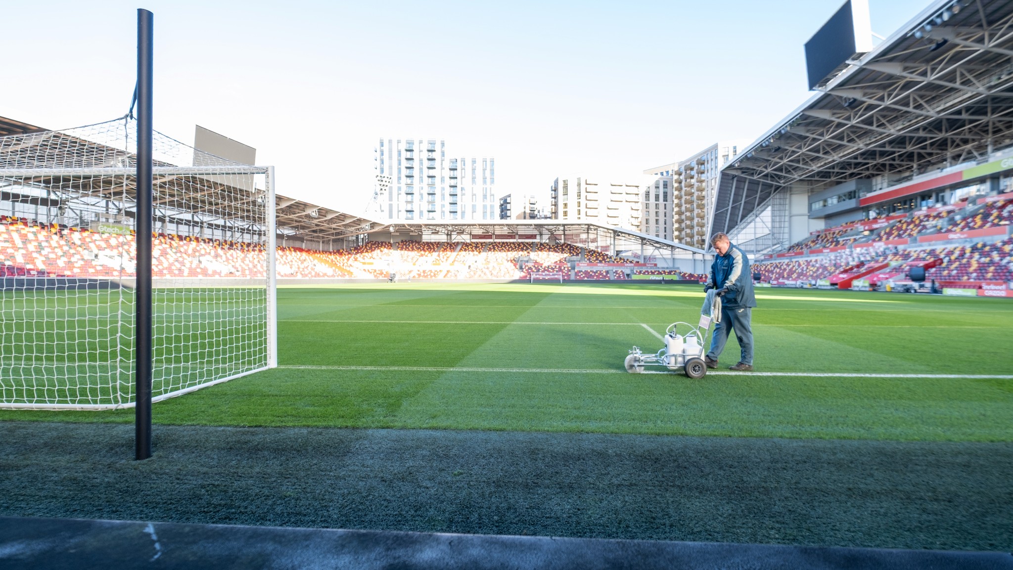 Two classic volkswagen beetles, one green, one cream.