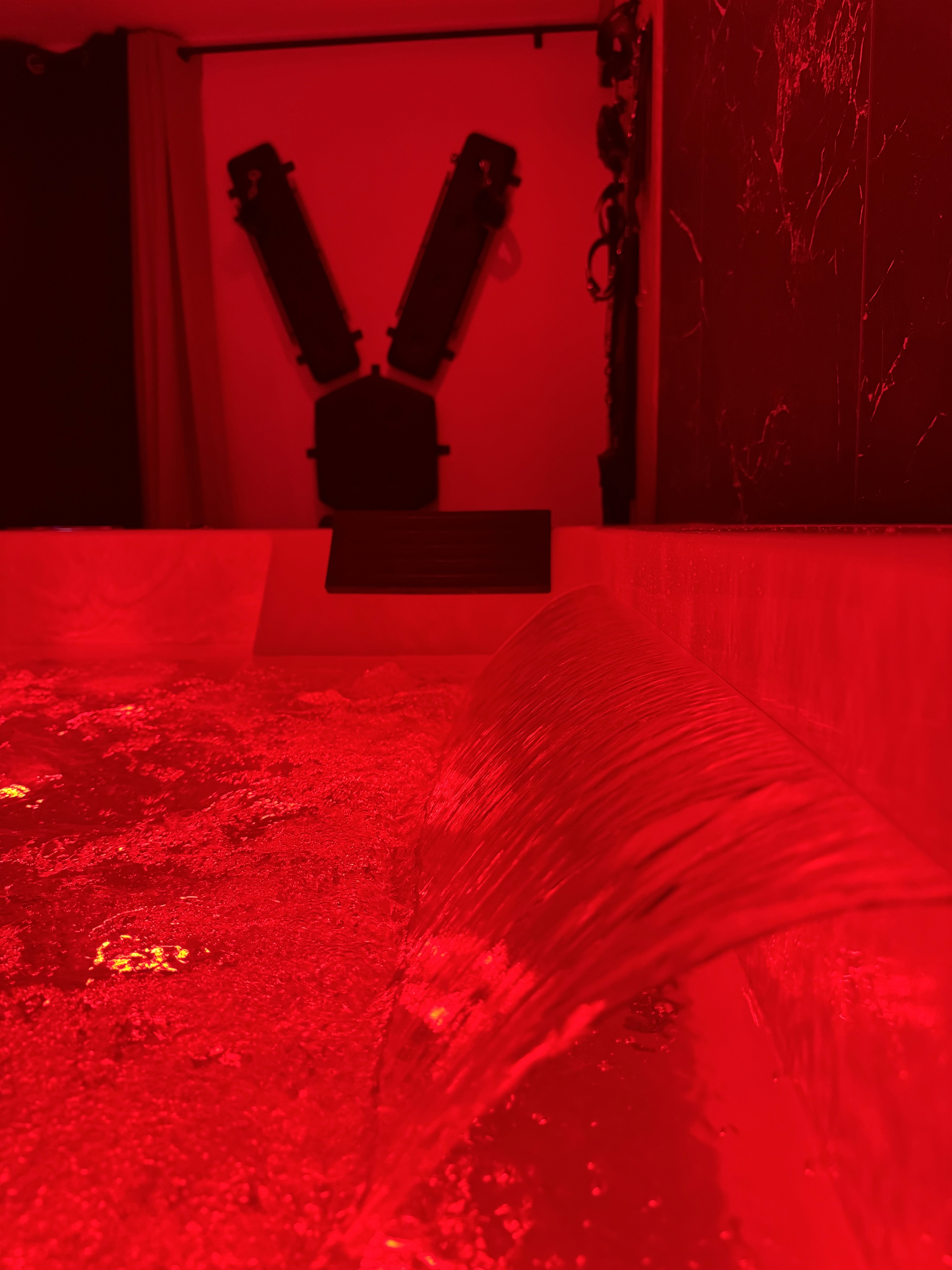 Sunset over calm ocean viewed through oval window.