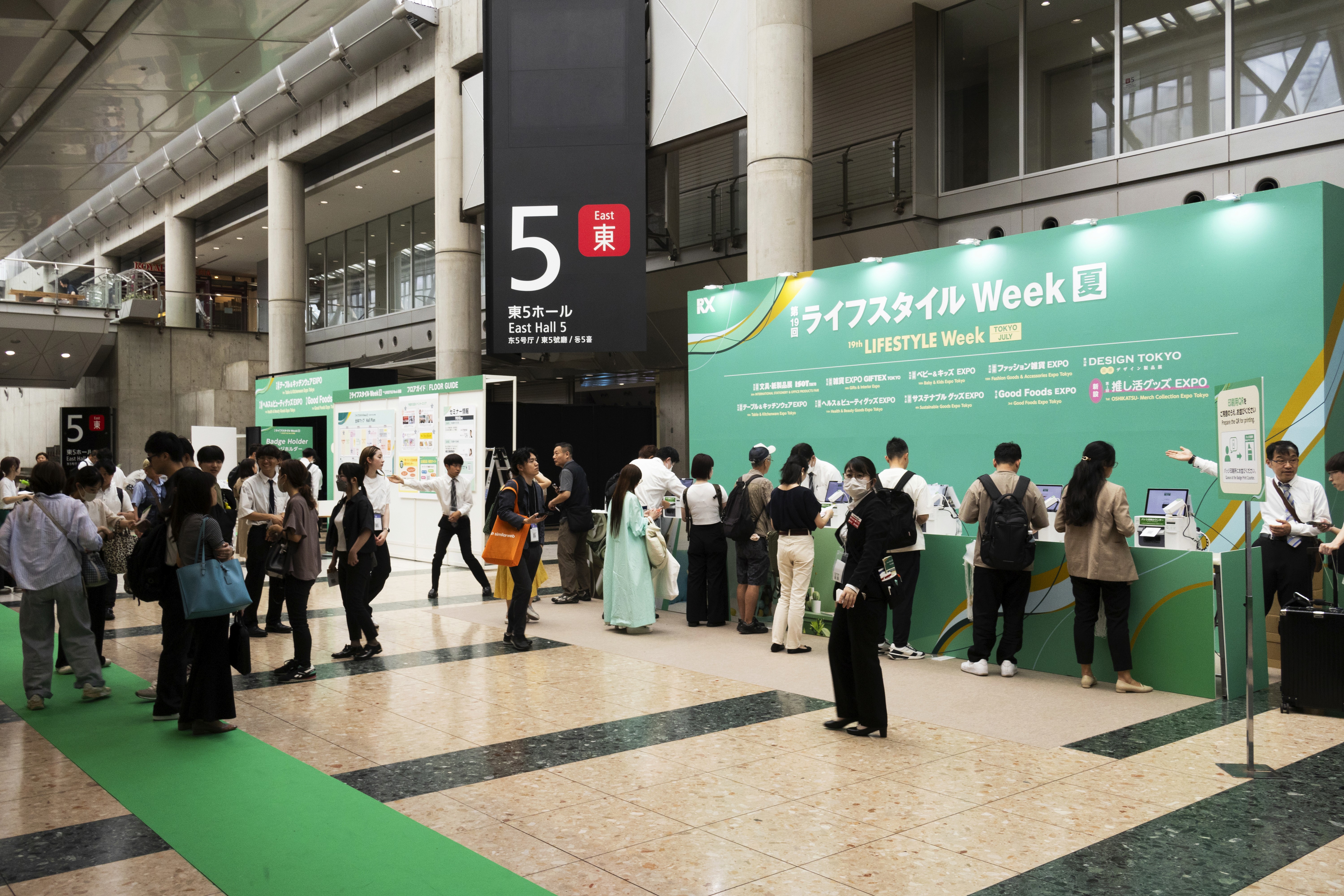 Group of young travelers sitting together in AlUla’s old town, sharing drinks and stories under palm trees on a sunny day.