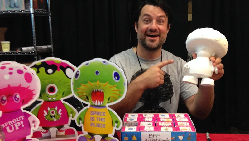 a man holding a mushroom shaped toy in his hand
