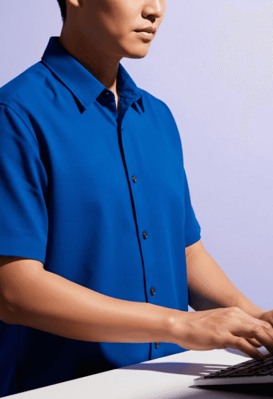 Man in blue shirt typing.
