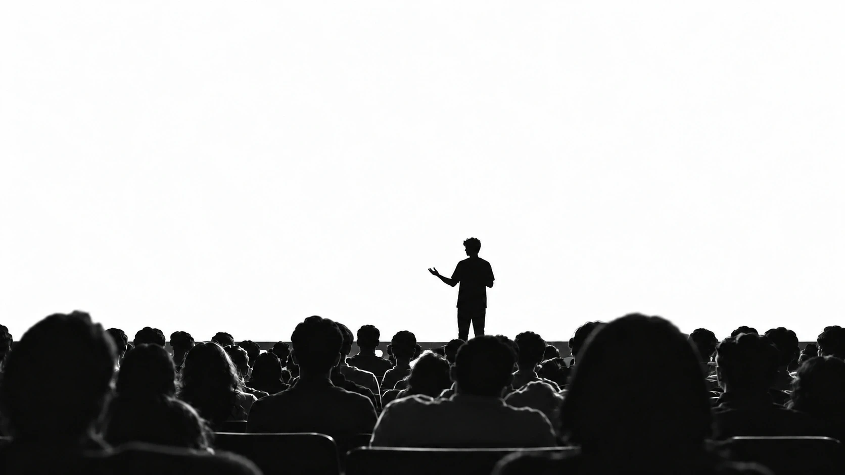 Silhouetted speaker addressing a seated audience