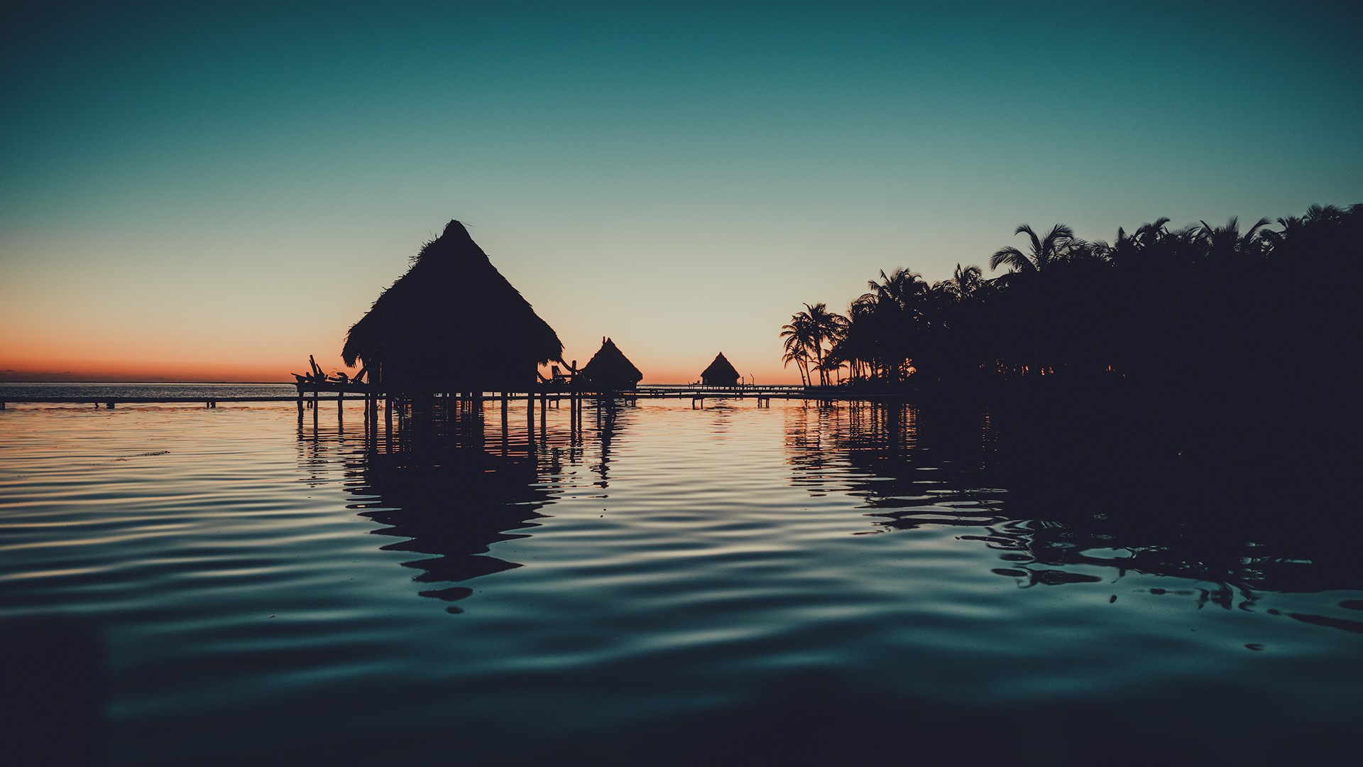Cabins on poles in the water on a remote island on Glovers Atoll, Belize