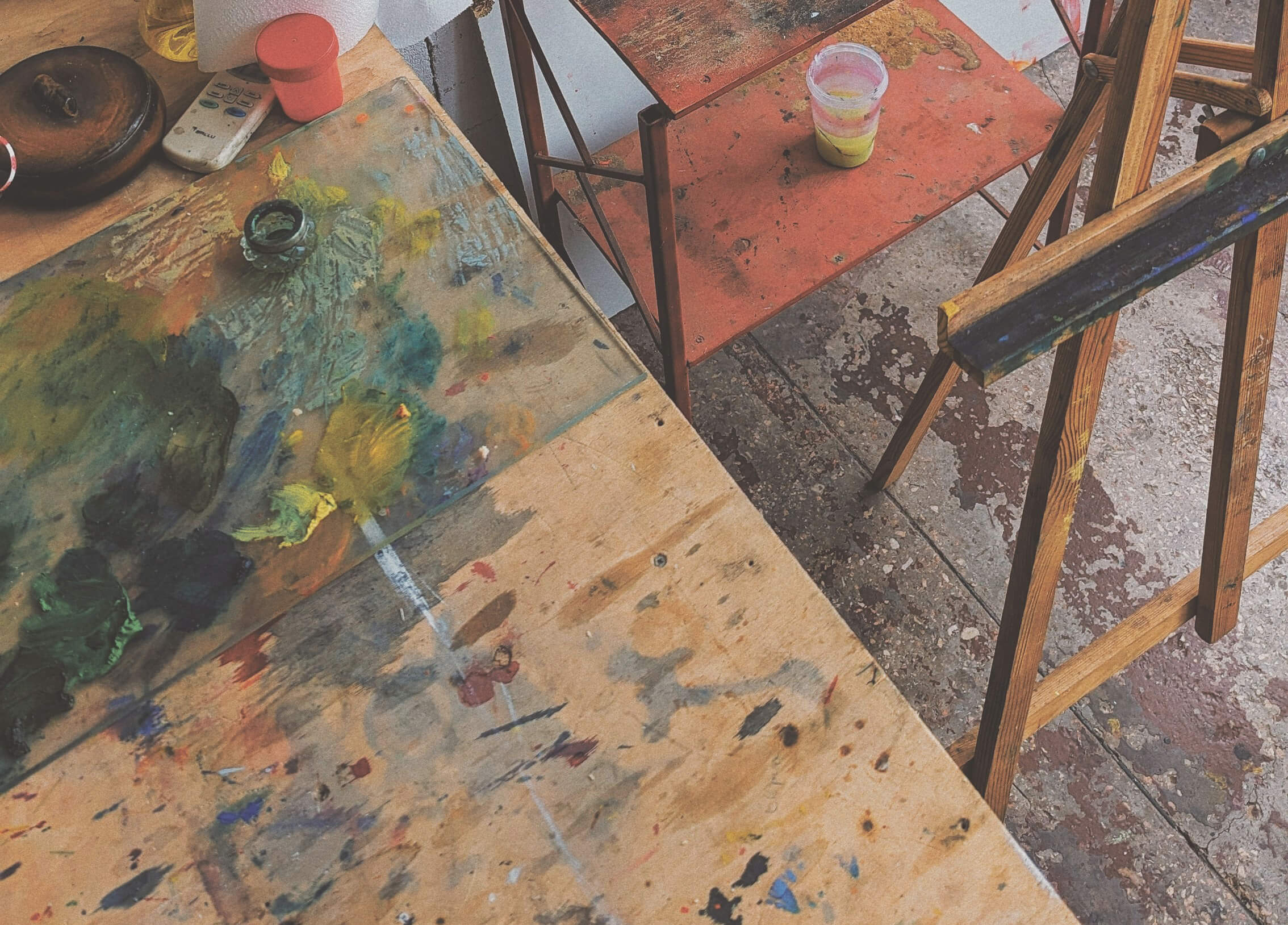 Paint-stained work tables and easels in an artist's studio.