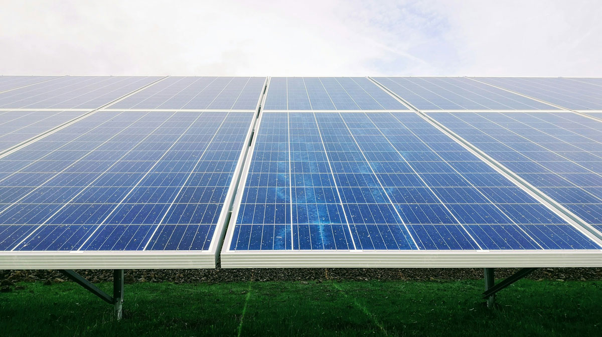 Solarmodule in einer Freiflächenanlage unter hellem Himmel