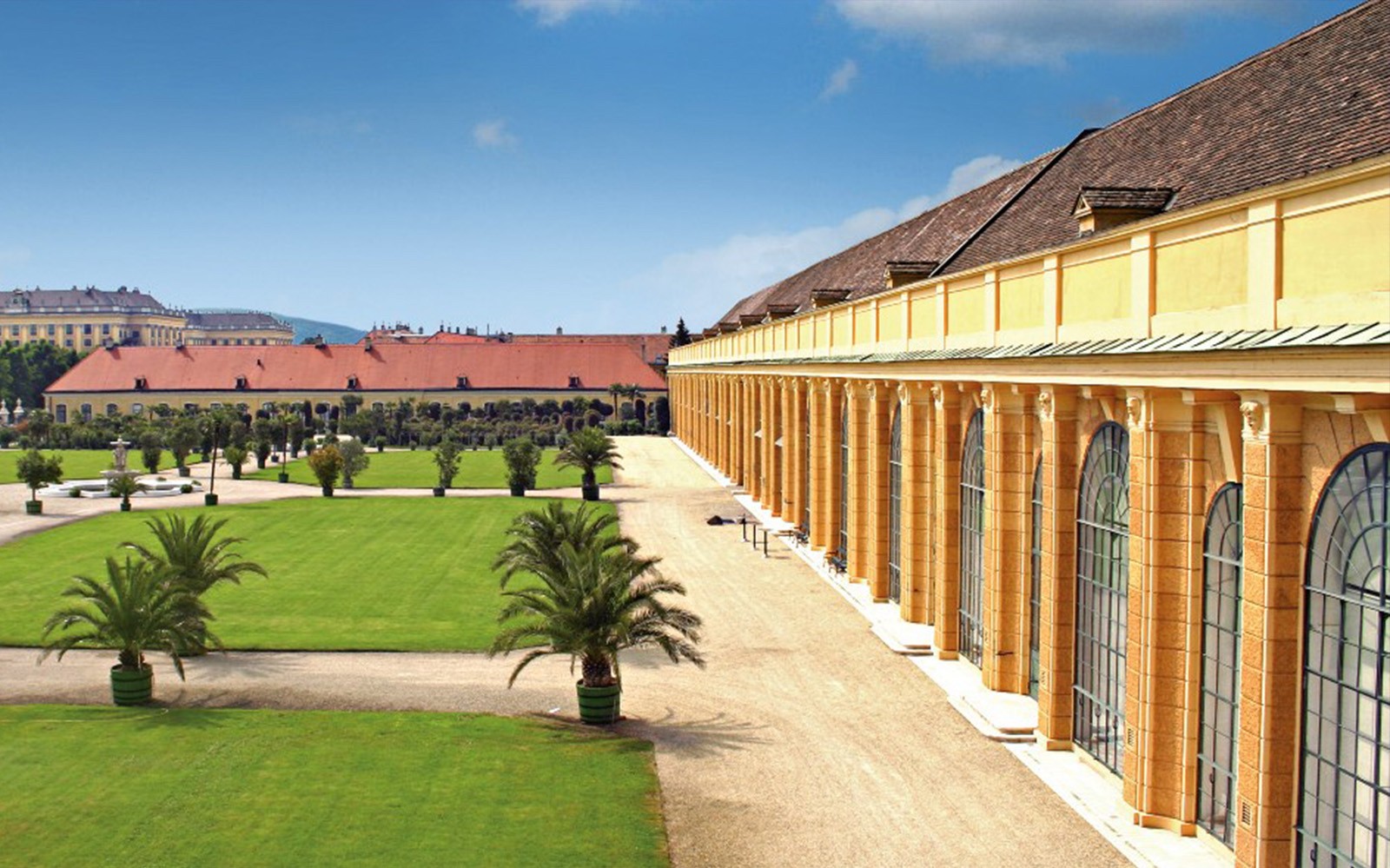 Schönbrunn Palace exterior with gardens and palm trees, Vienna, Austria.