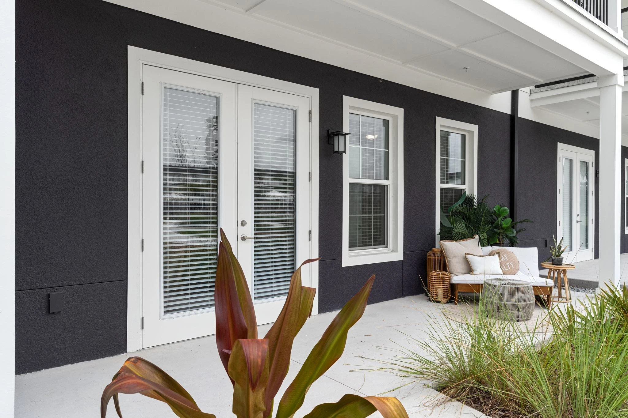 A black house featuring white trim and white shutters, showcasing a striking contrast in its architectural design.