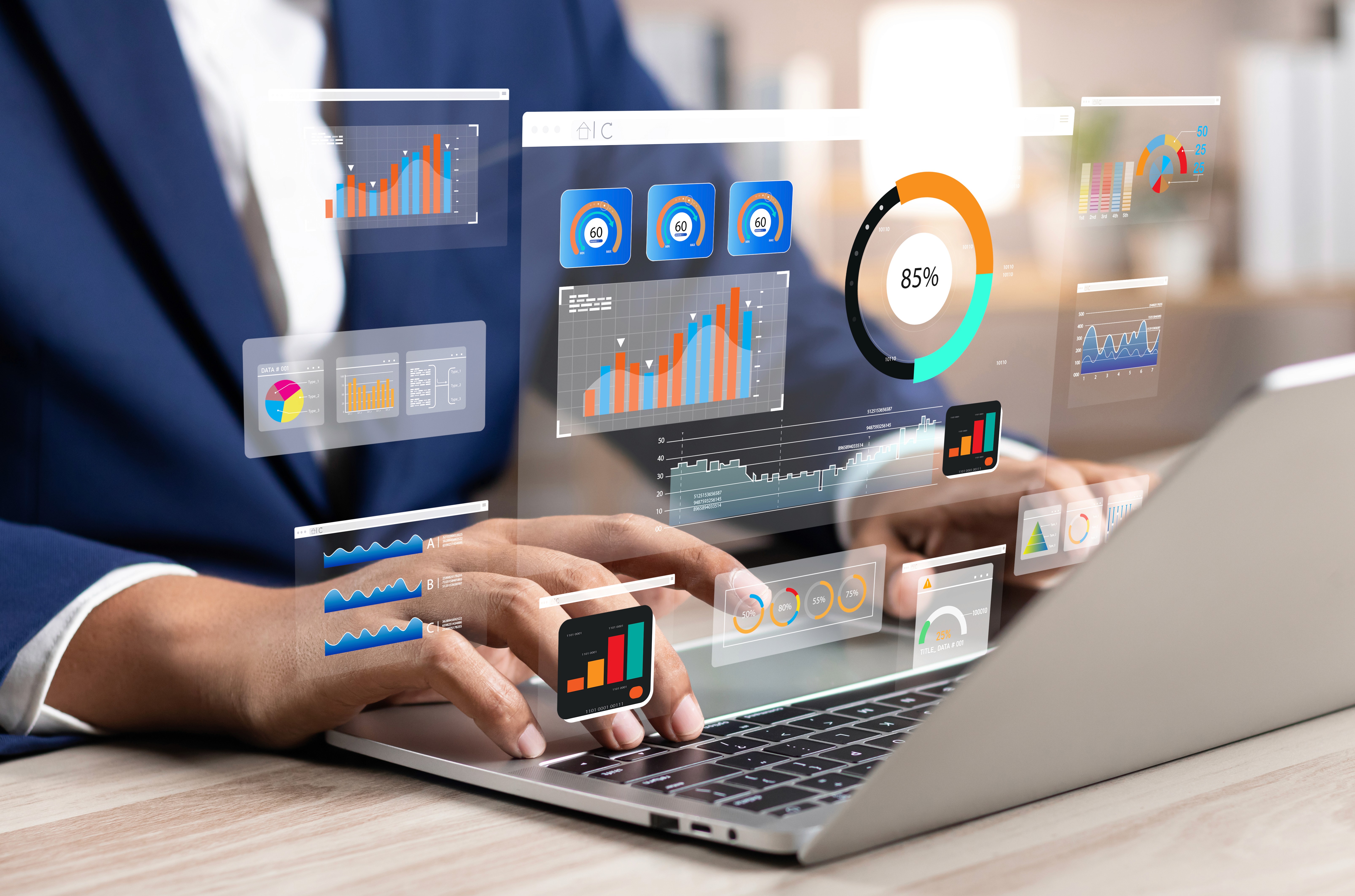 A person in a suit operates a laptop displaying futuristic digital dashboards and analytics, symbolizing system administration and workflow monitoring.