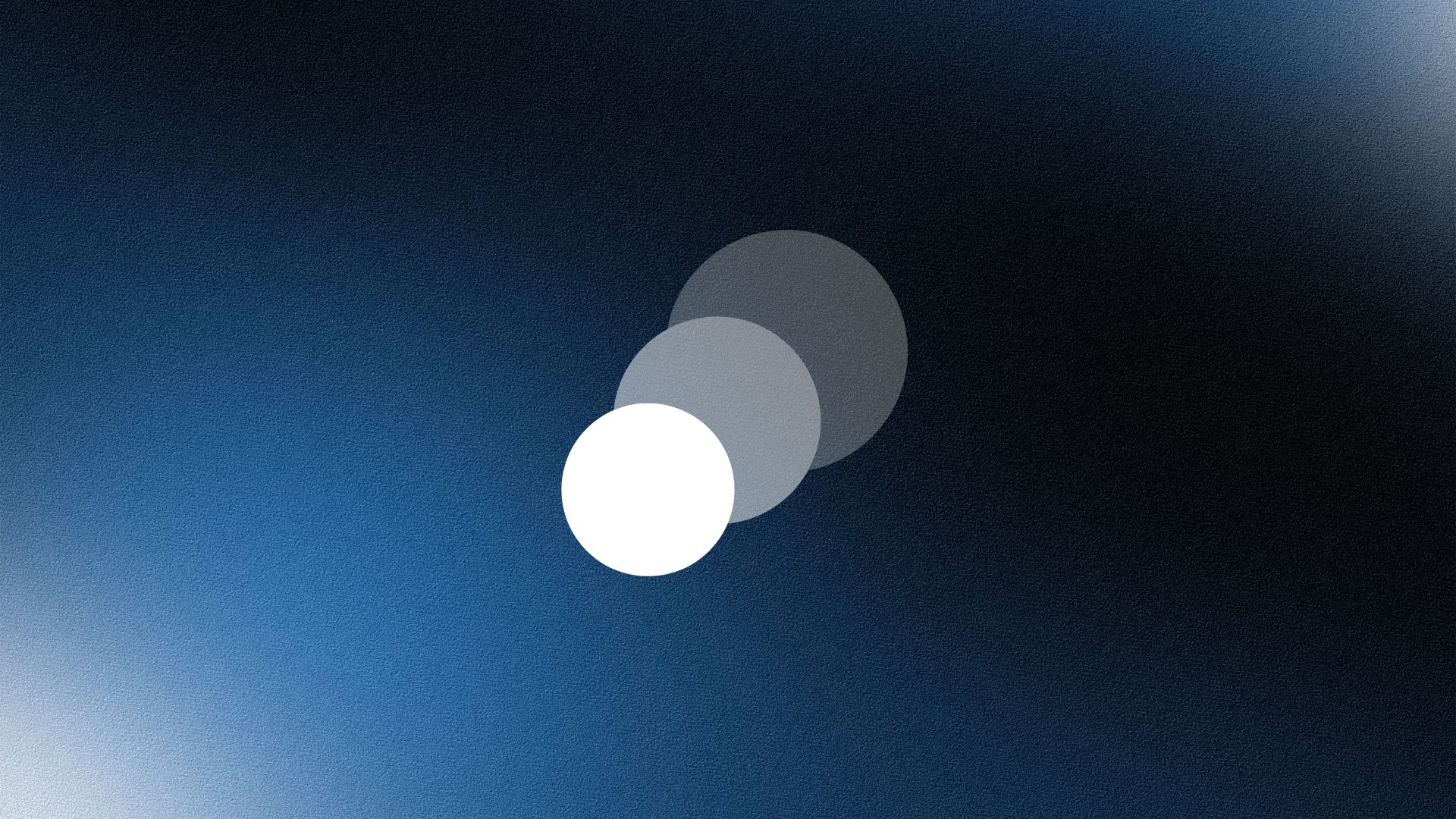 Smiling woman wearing a beige blazer and grey shirt, holding a folder while standing by a sunlit wall.