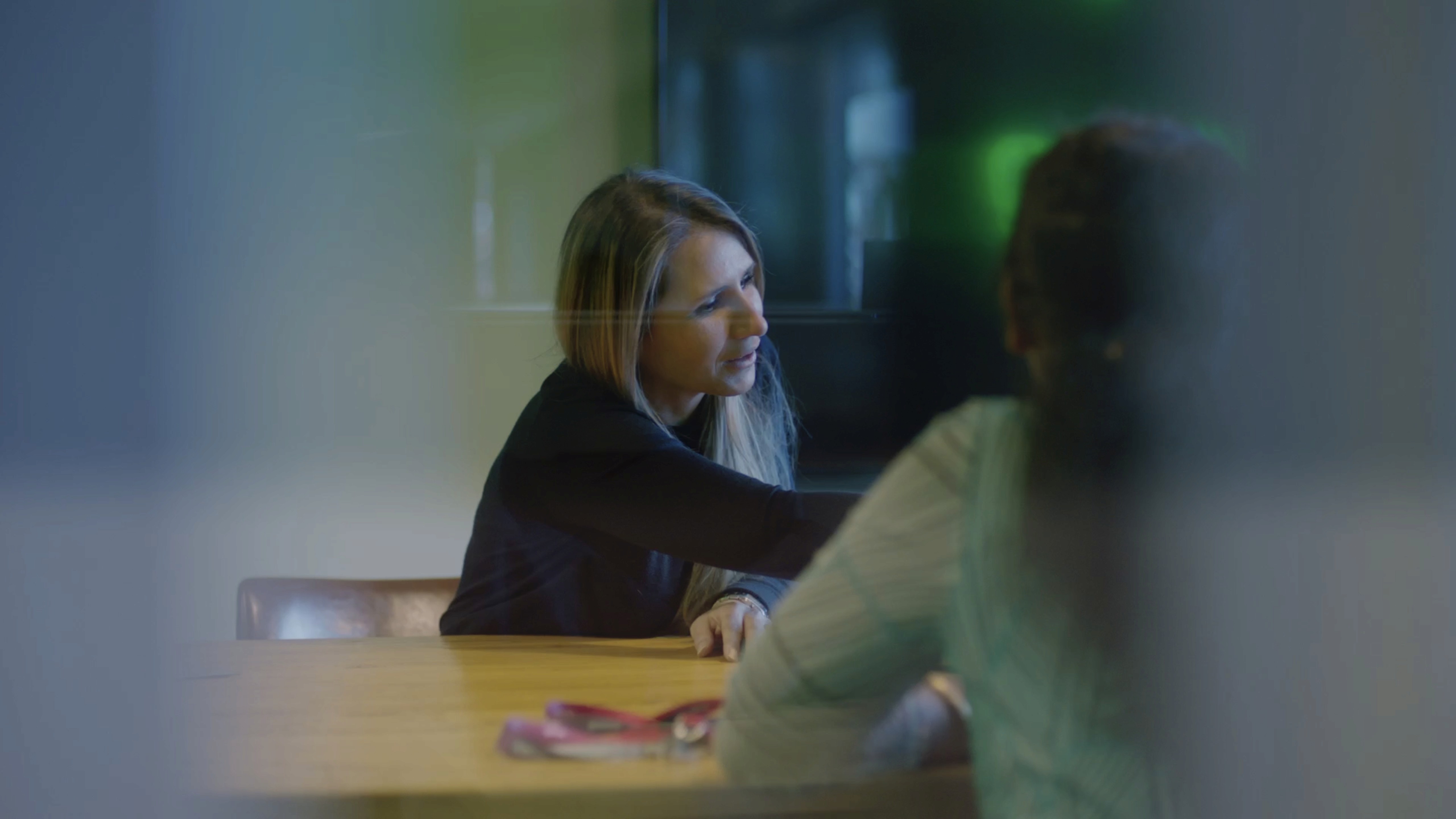 woman pointing to scren over-the-shoulder of another woman