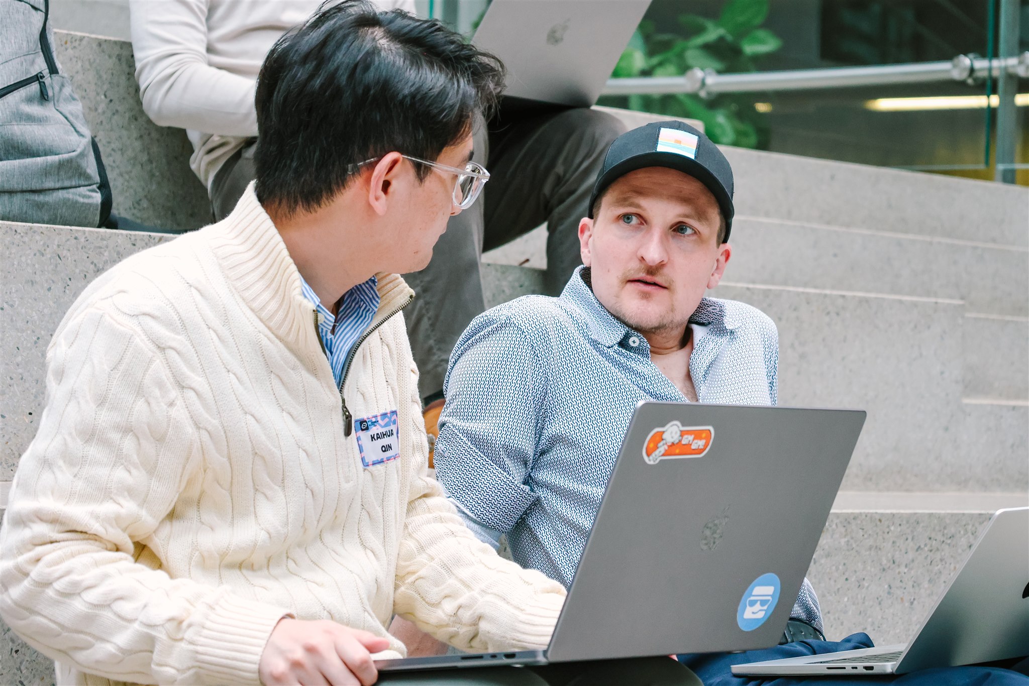 Attendees working and discussing with laptops at EthereumZüri tech event