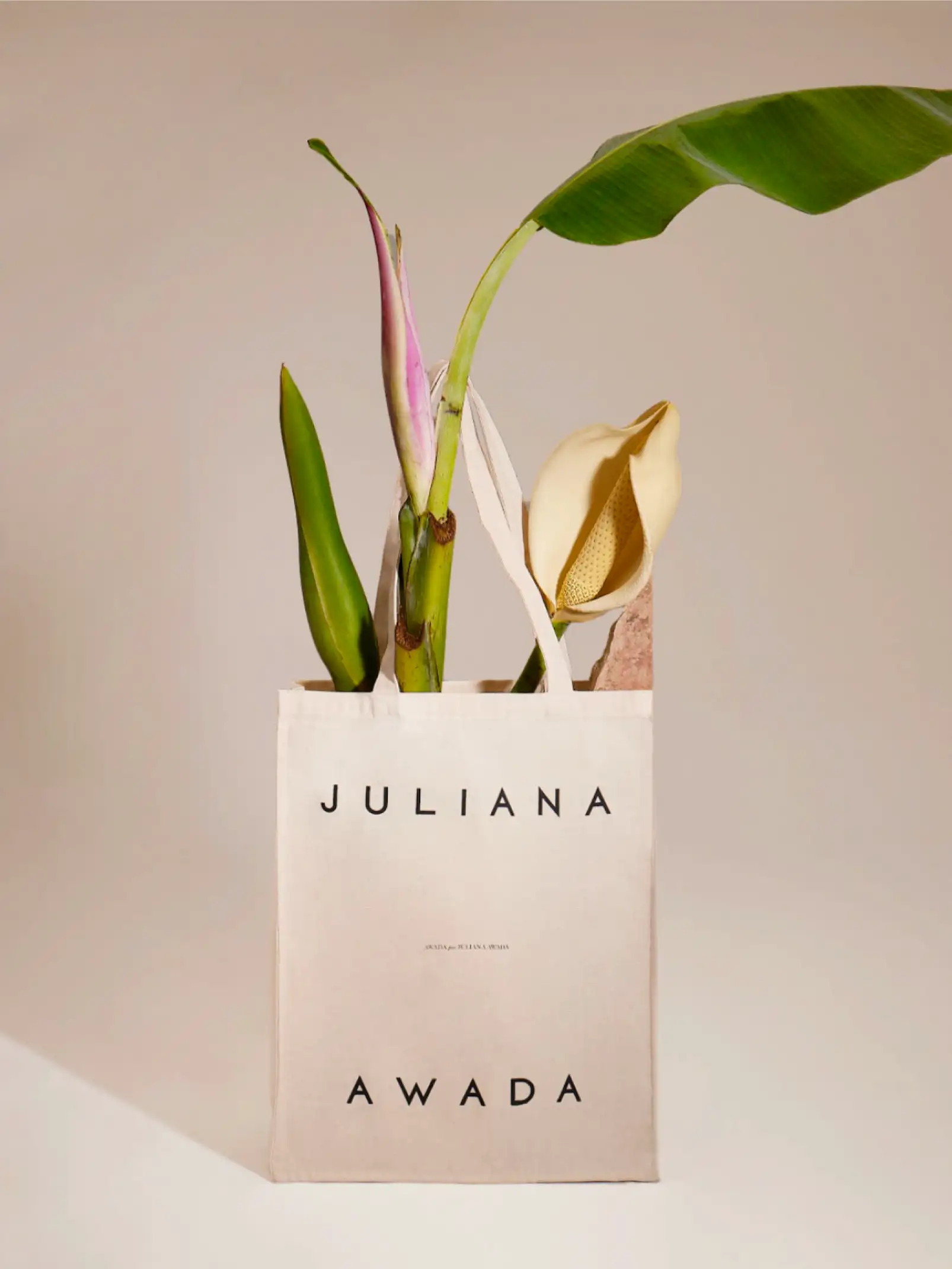 Bolsa de tela beige con plantas tropicales para marca de lifestyle sustentable enfocada en elegancia natural.