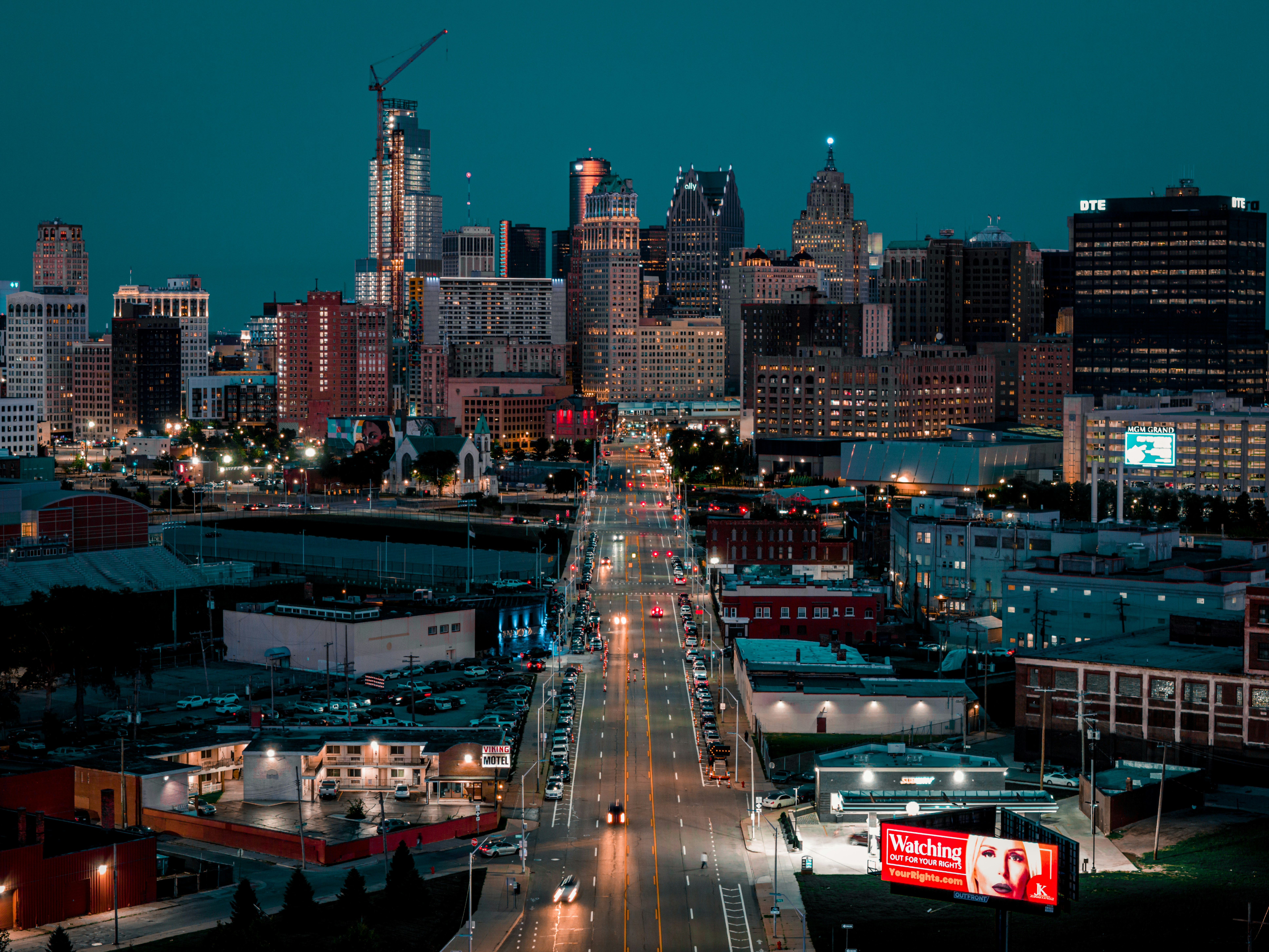 A view of a city at night from the top of a hill