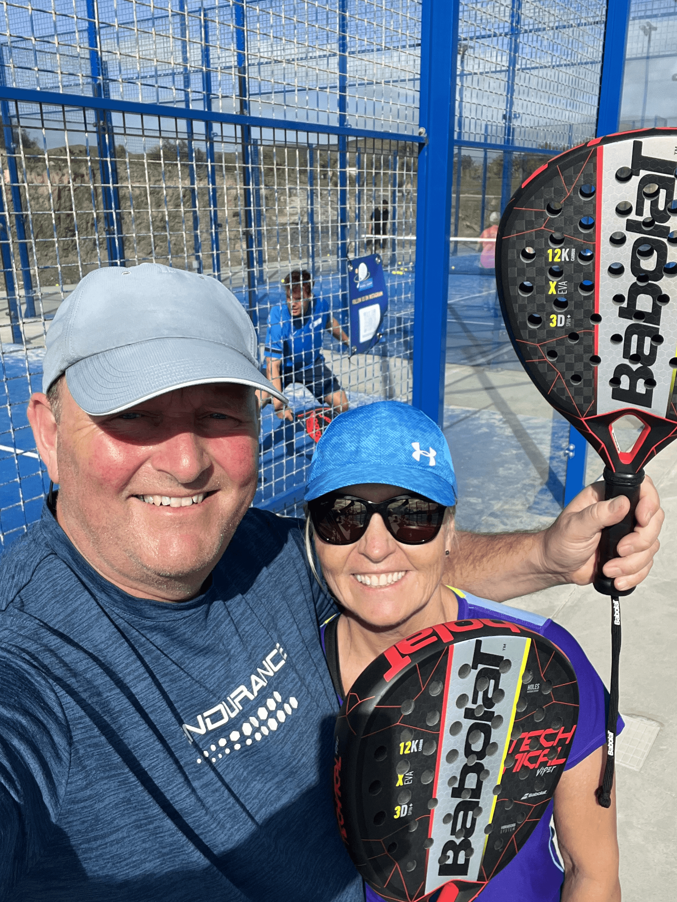woman in red tank top and black shorts holding tennis racket