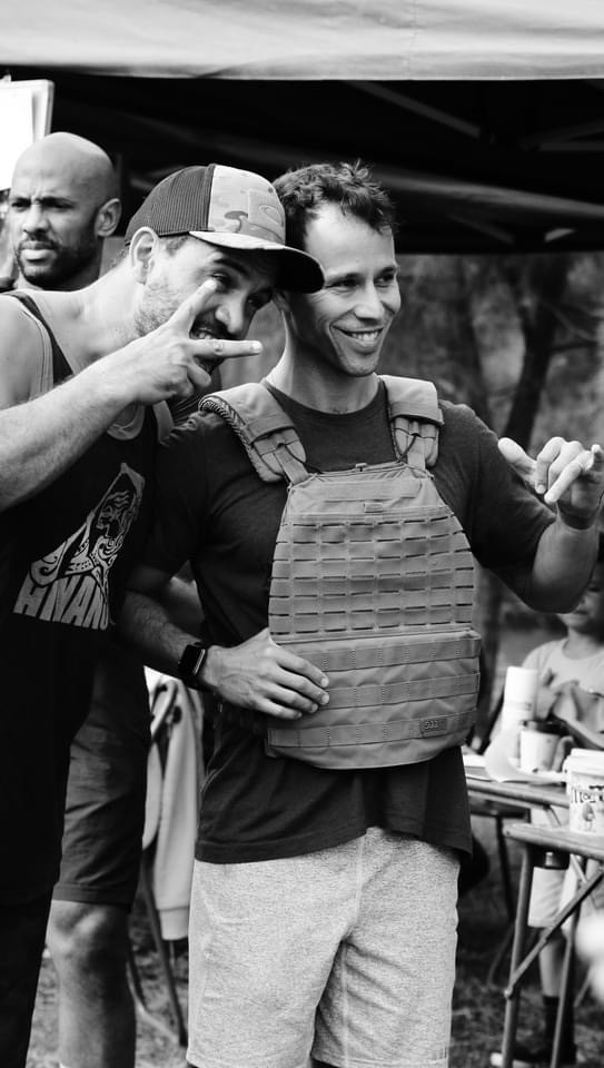 Close-up of a dark green leaf showing its textured surface and central vein against a muted background.