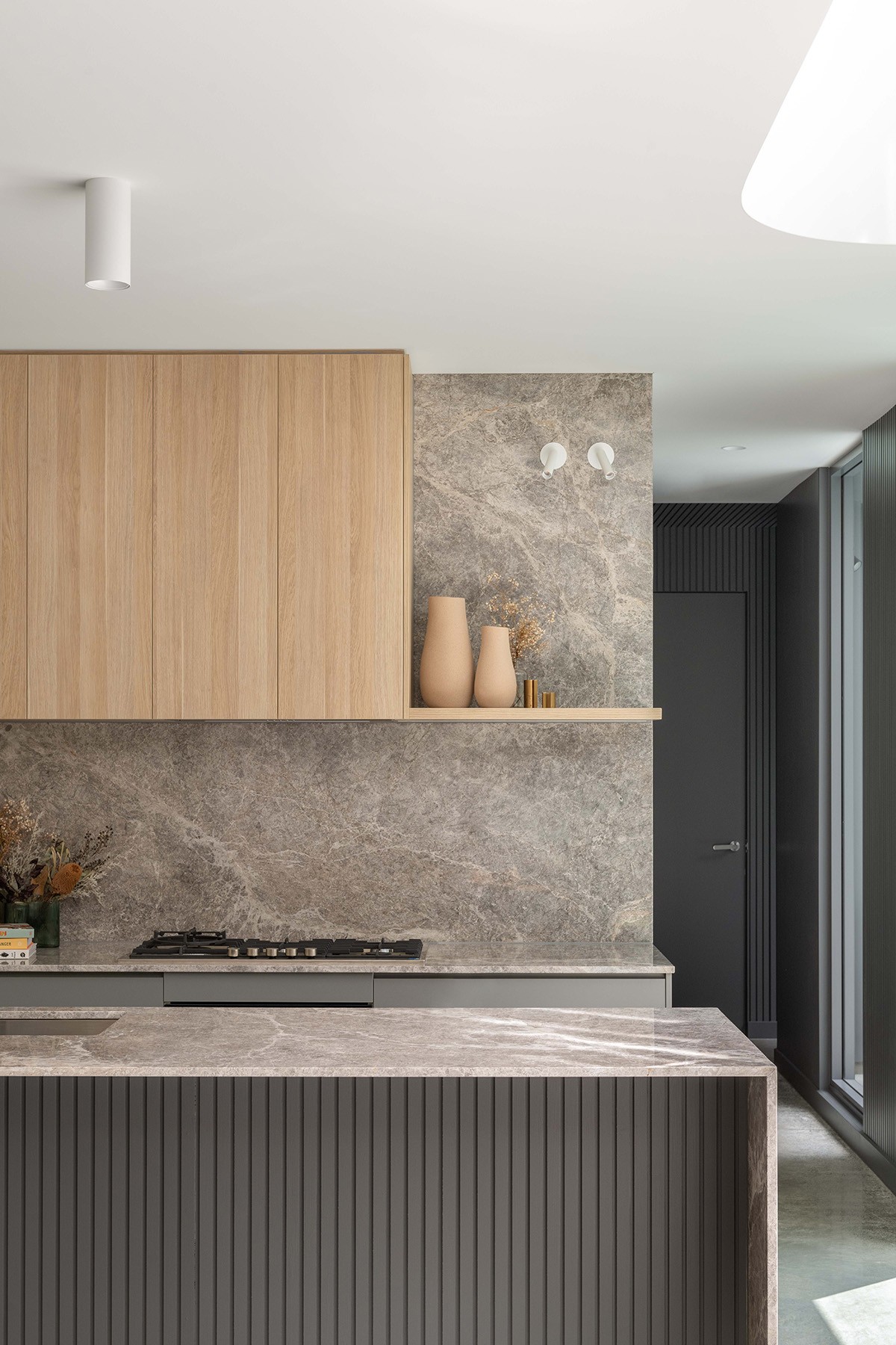 Kitchen joinery detail at The Stables, combining timber cabinetry, stone finishes, and a restrained palette that anchors the open-plan interior.