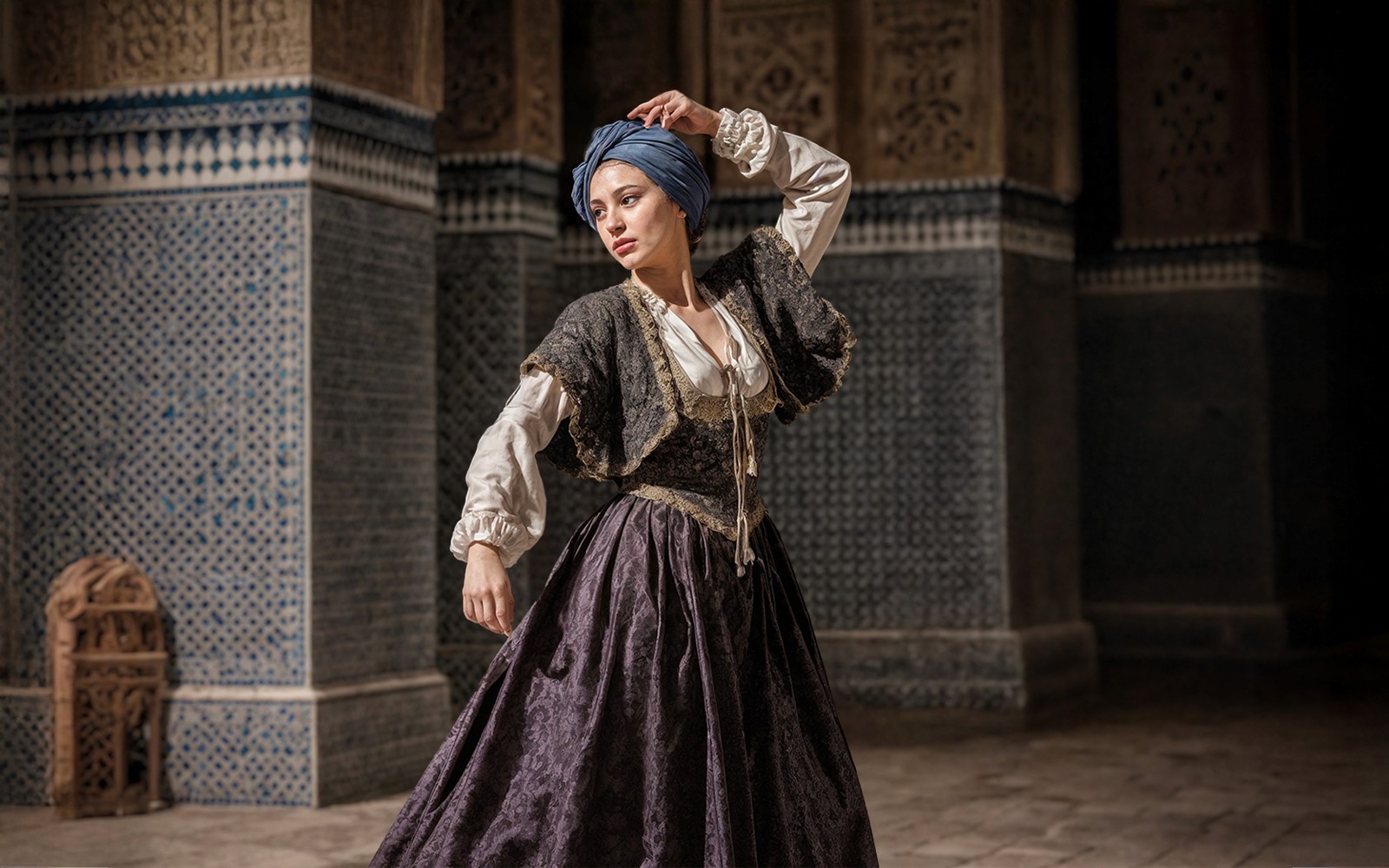 Intérprete femenina en atuendo español del siglo XVI en el recorrido nocturno del Alcázar de Sevilla.