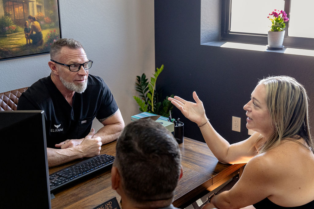 a woman talks to an elixium health staff member
