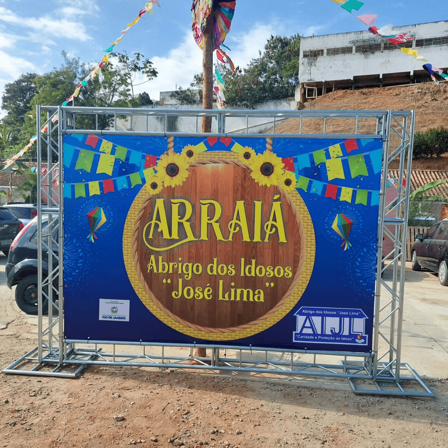 Banner promocional de evento Arraiá no Abrigo dos Idosos José Lima em Bom Jesus do Itabapoana, com decoração temática junina e detalhes coloridos, incluindo logos de patrocinadores e apoio da Grafanp.