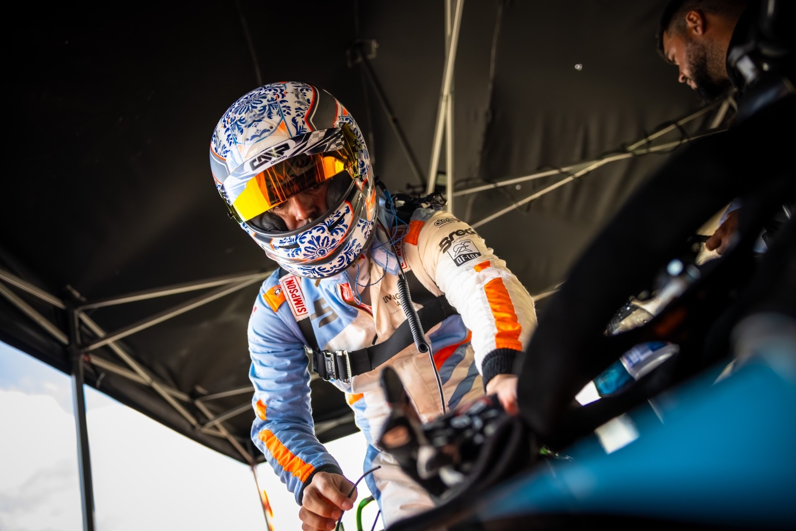Racing driver getting into the car