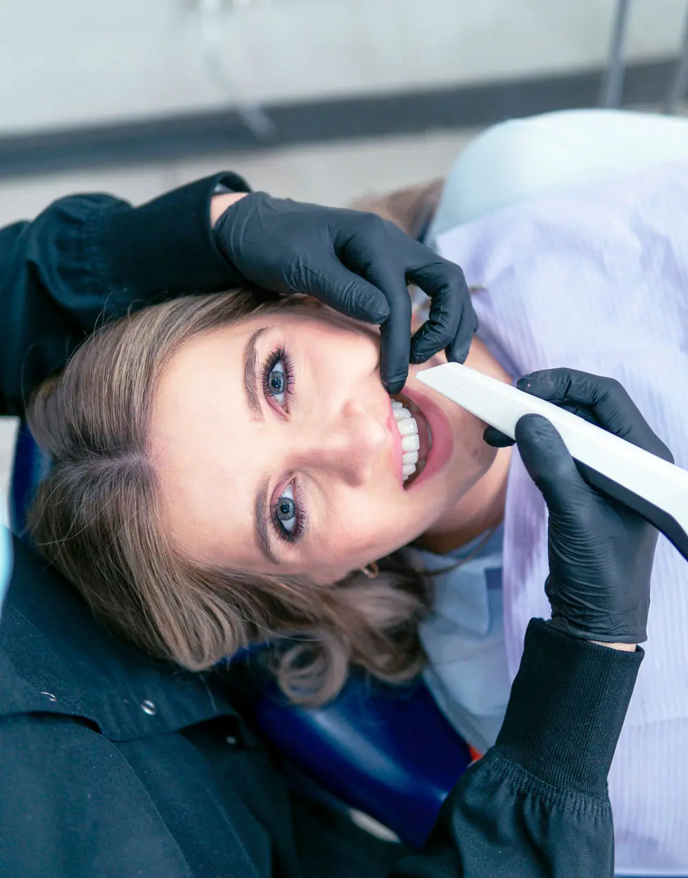 Woman on chair with teeths being checked.