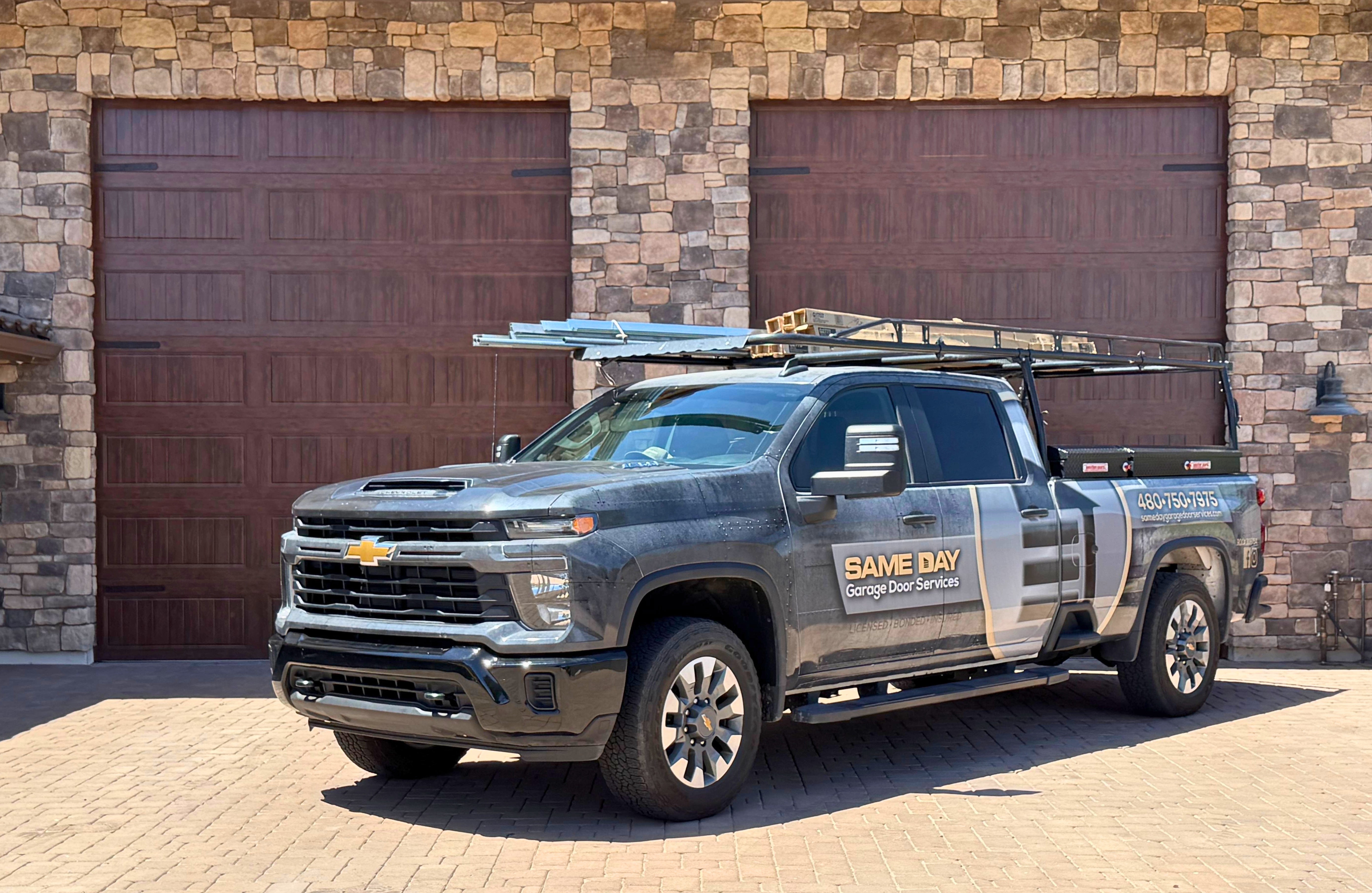 Professional photo of a Same Day Garage Door Services vehicle in front of a newly installed garage door