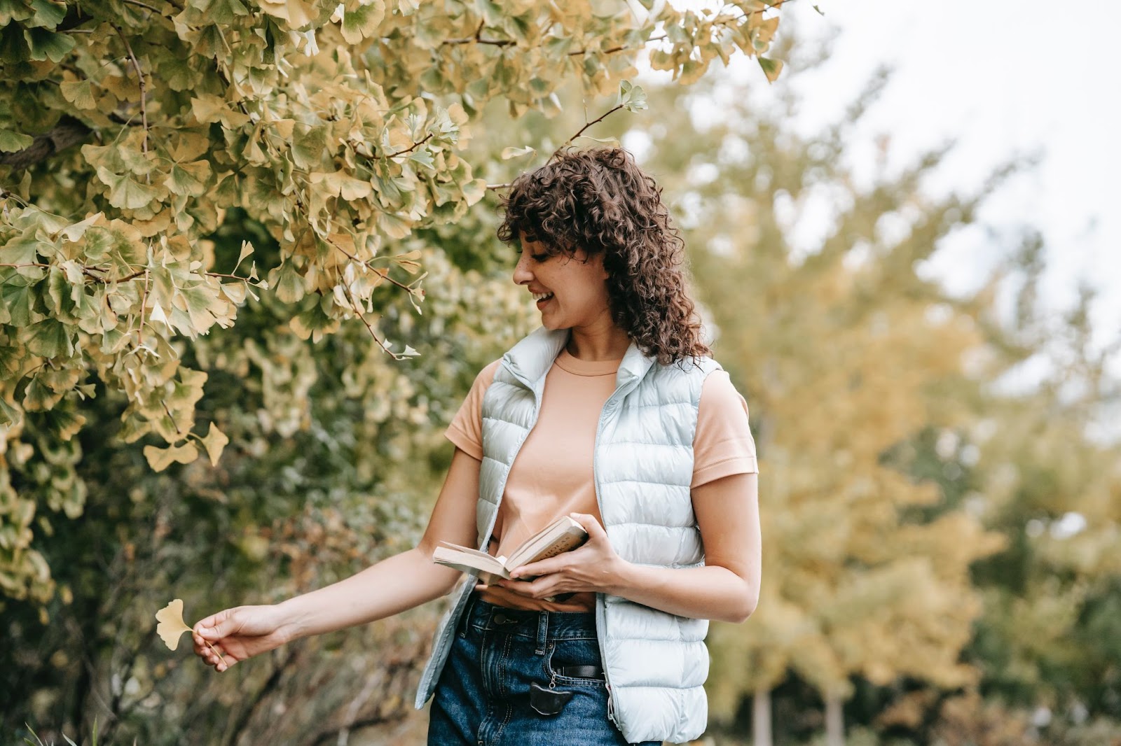 Woman reading a book outdoors, showing a screen-free break.