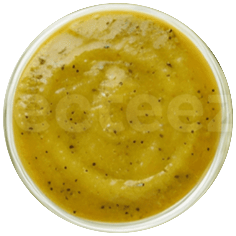 A bright, modern dining room featuring a long light wood table set with several matching wooden chairs and white cushions, illuminated by natural light streaming through large windows overlooking a lush green and sunlit yard.